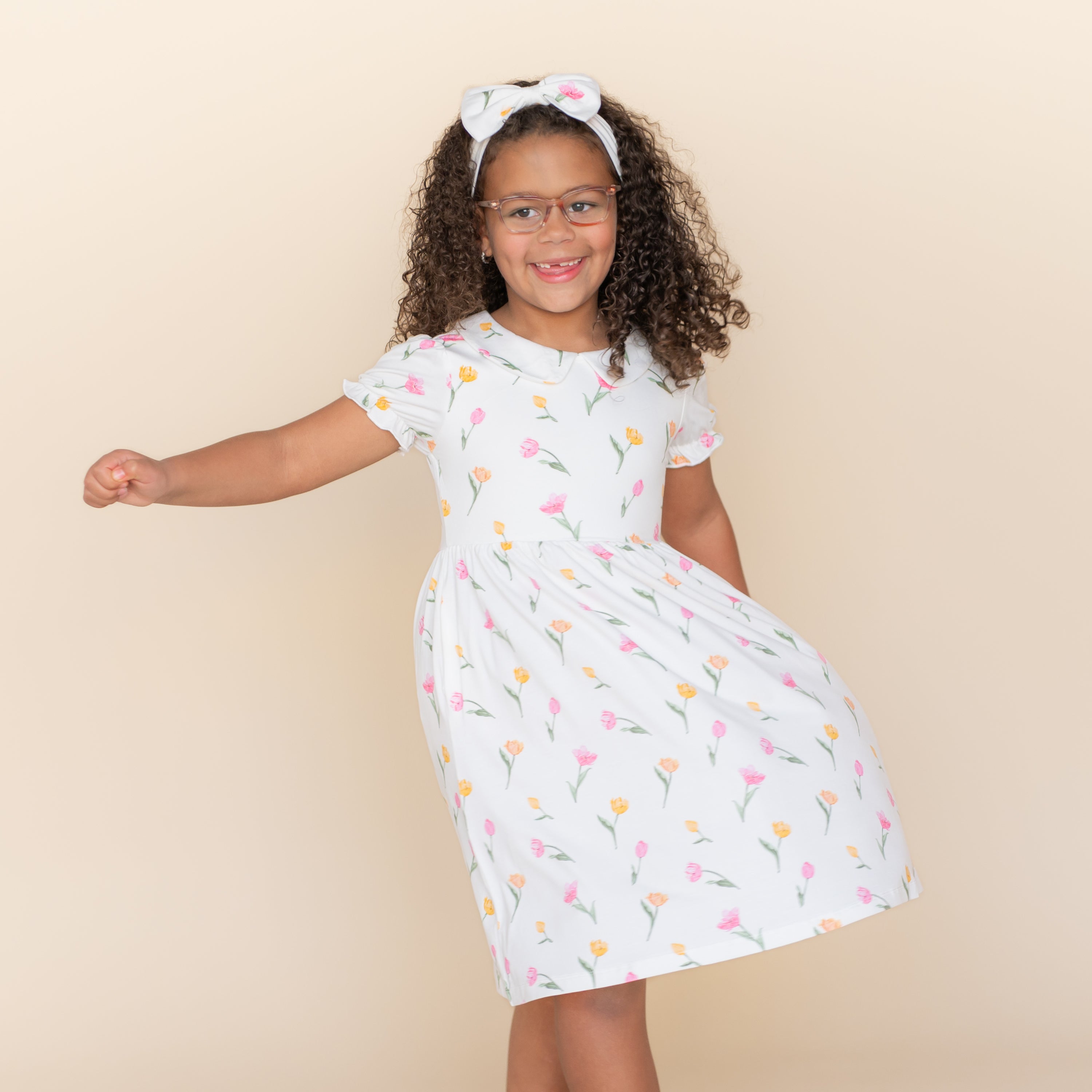 Young girl modeling with her hand in the pocket of the Peter Pan Collar Dress in Tulip