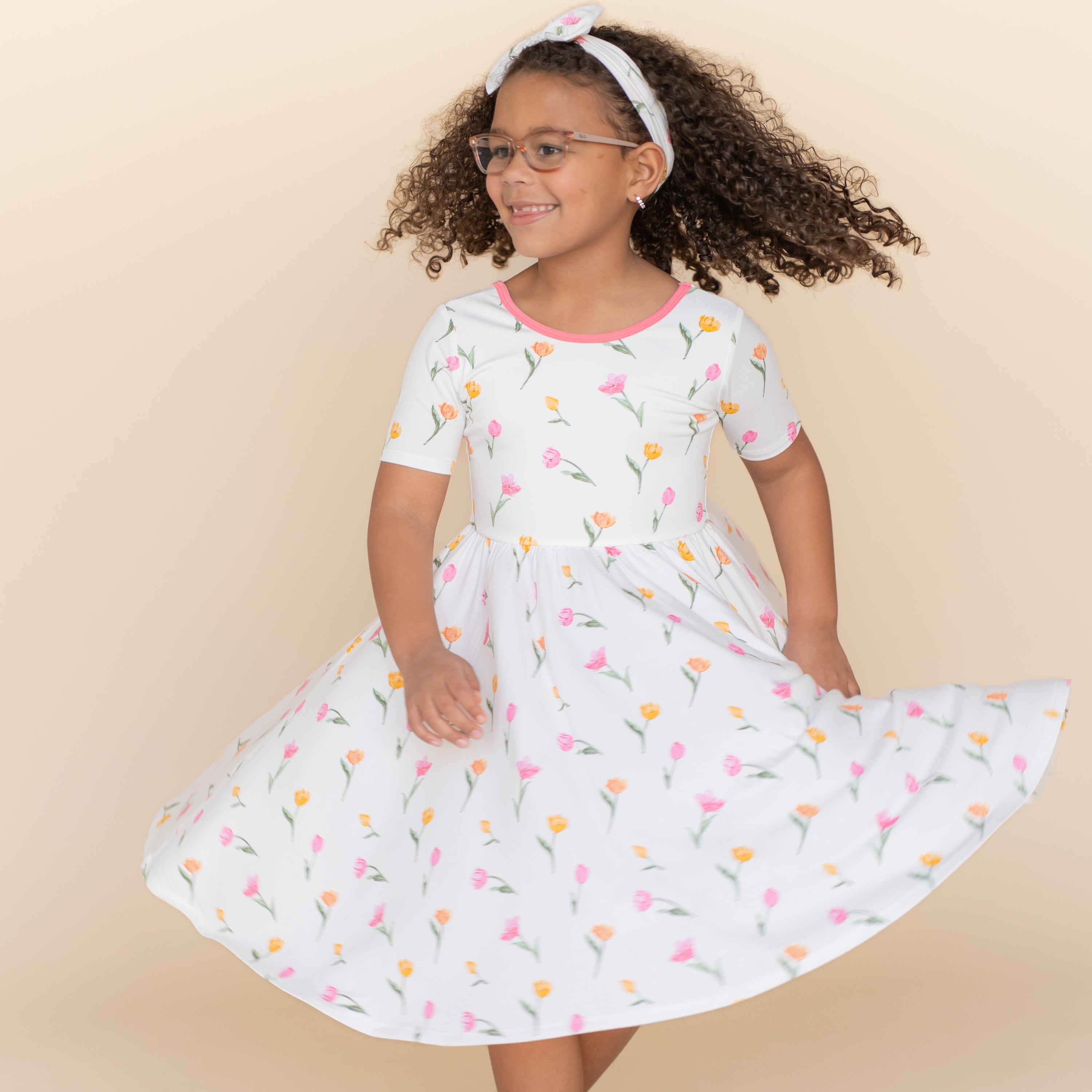 Young girl twirling wearing the Twirl Dress in Tulip
