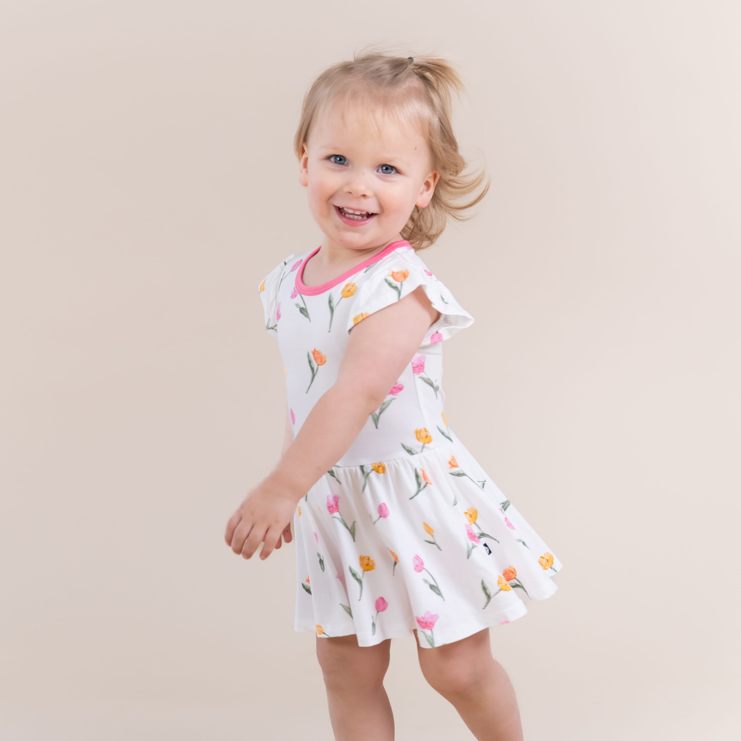 Young girl swaying wearing the Twirl Bodysuit Dress in Tulip