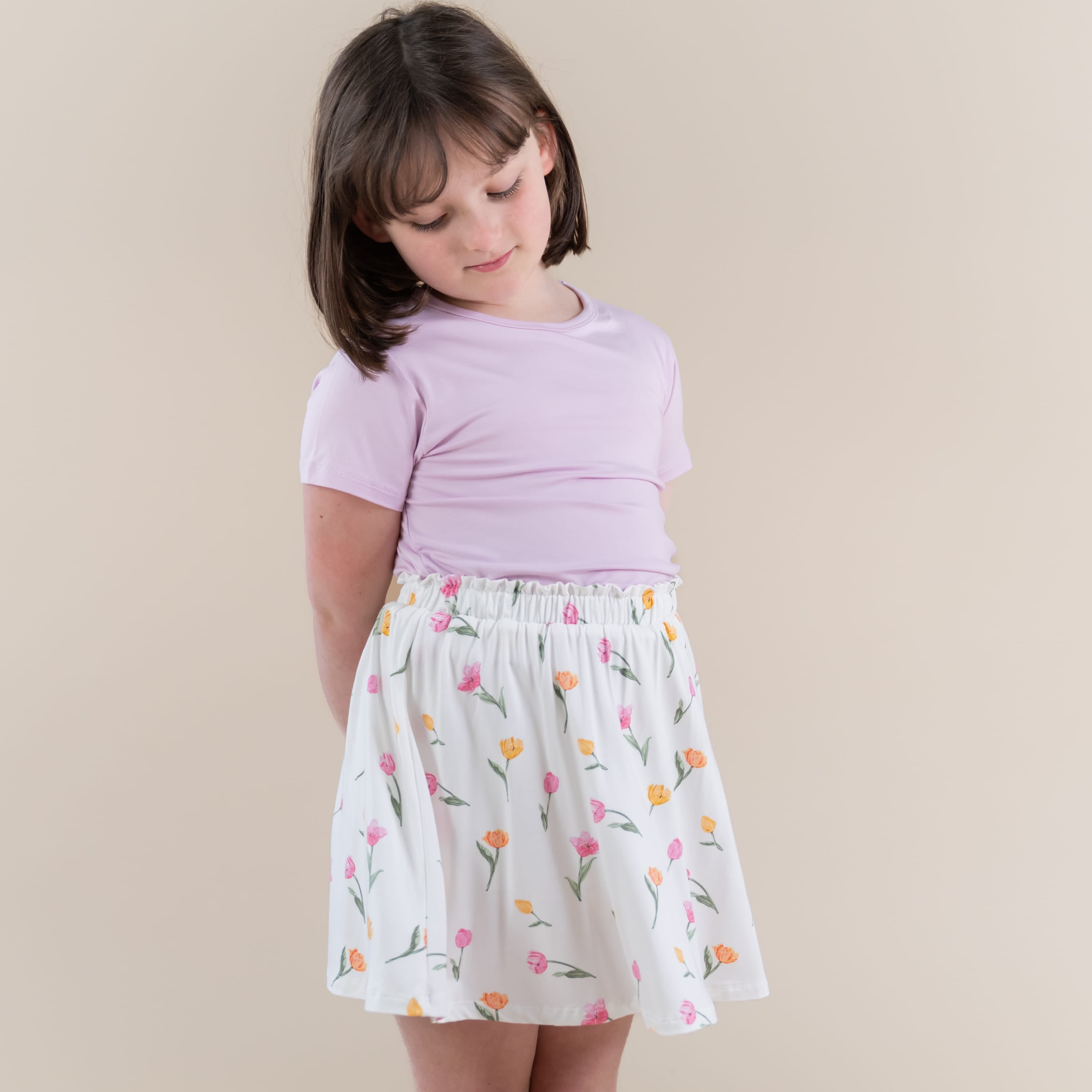 Young girl posing wearing the Toddler Skort in Tulip and Thistle basic tee