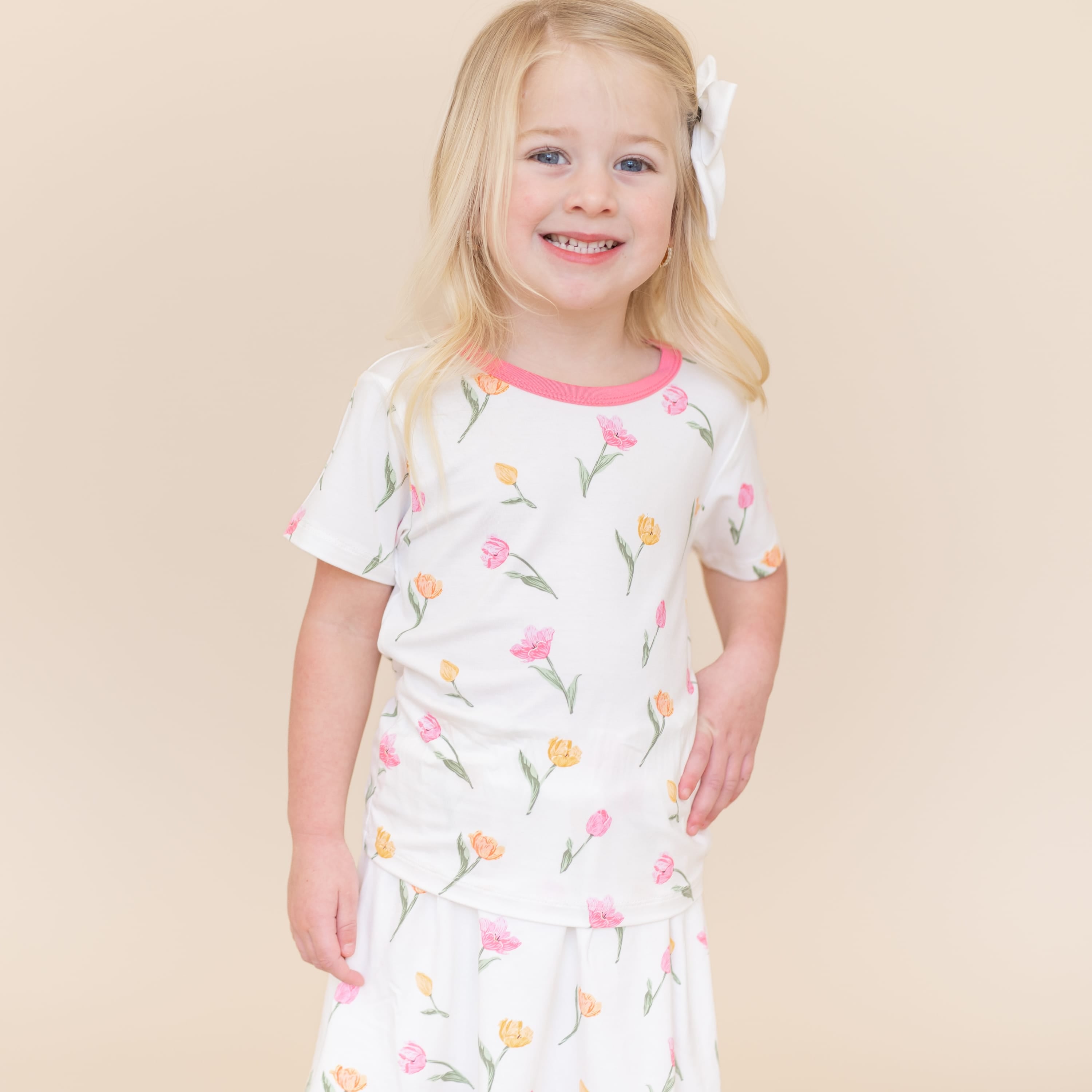 Young girl posing wearing the Toddler Basic Tee in Tulip and matching skort