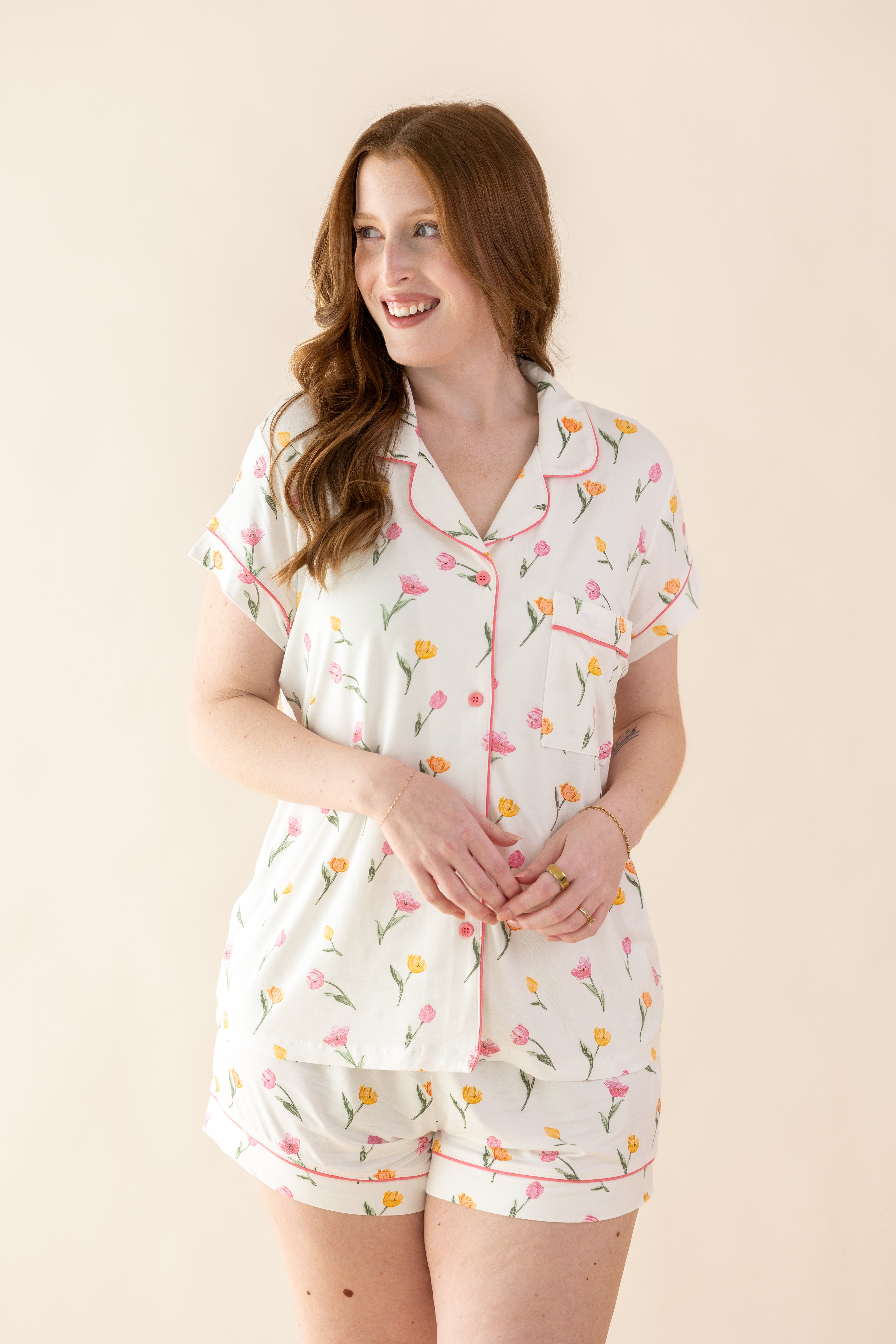 Female modeling the Women's Short Sleeve Pajama Set in Tulip standing in front of a light cream background