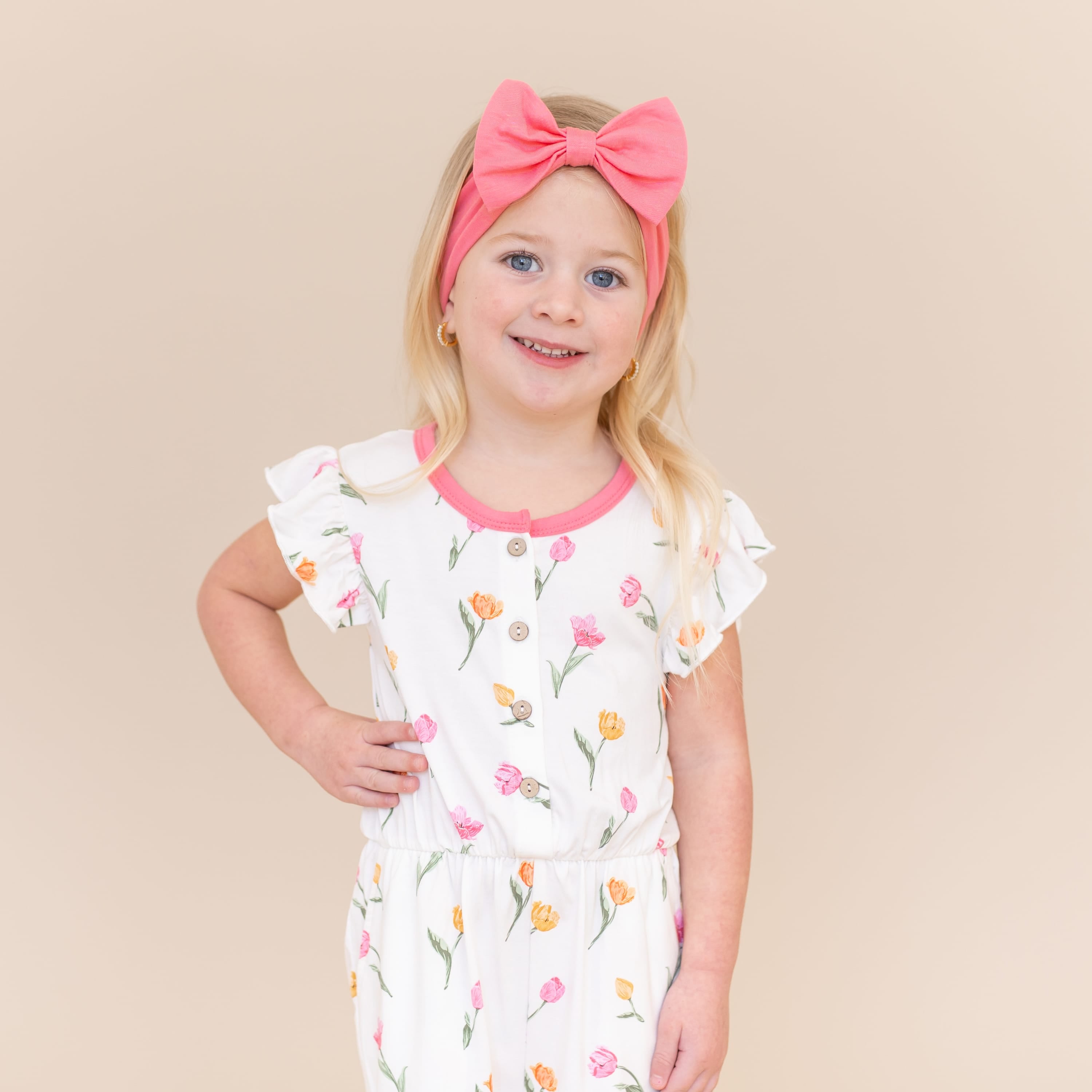 Close up young girl modeling the Flutter Sleeve Romper in Tulip