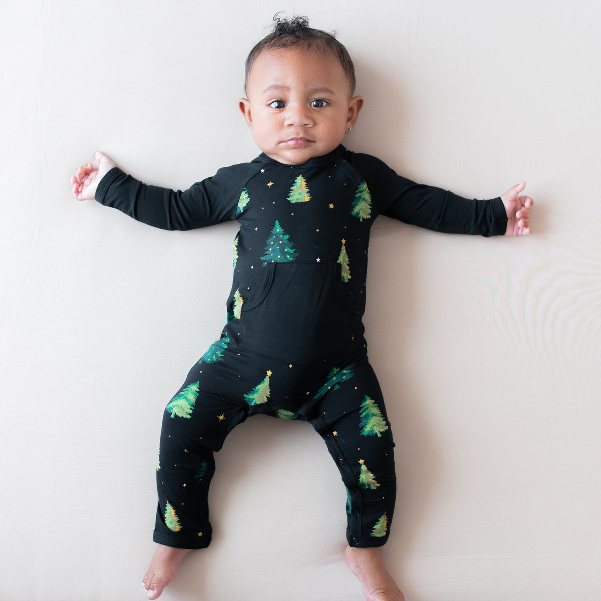 Young infant laying down wearing the Longall in Twinkle Tree