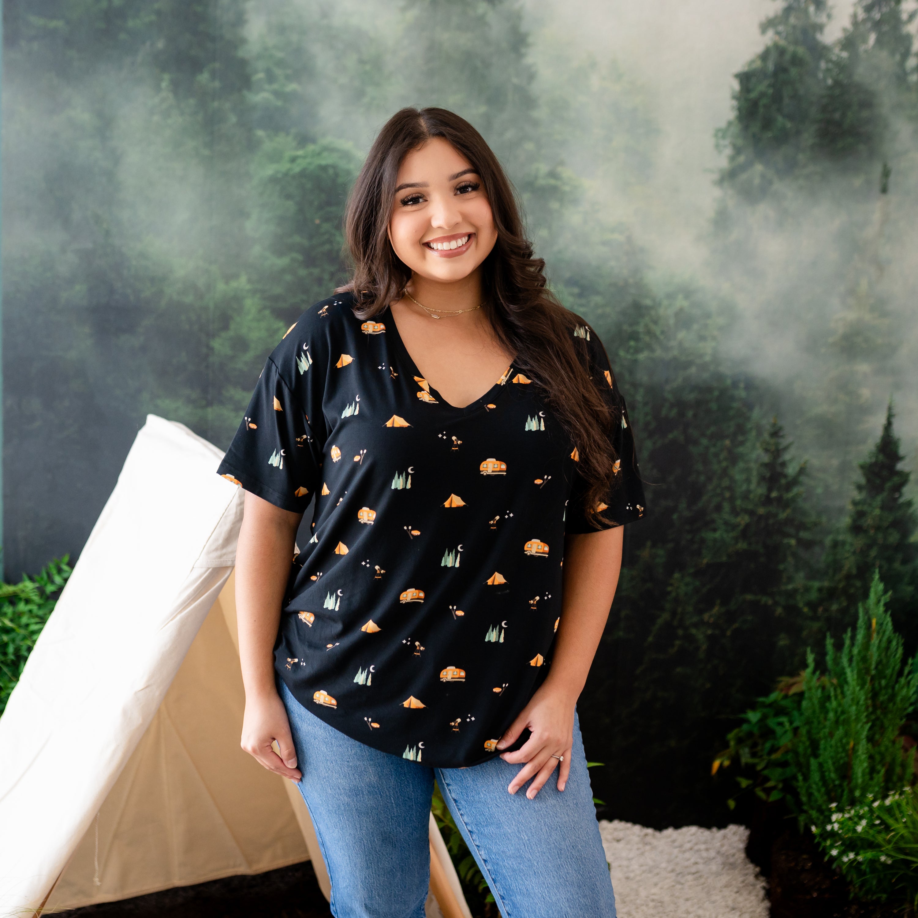 Smiling female model wearing the Women's Relaxed Fit V-Neck in Under the Stars paired with jeans