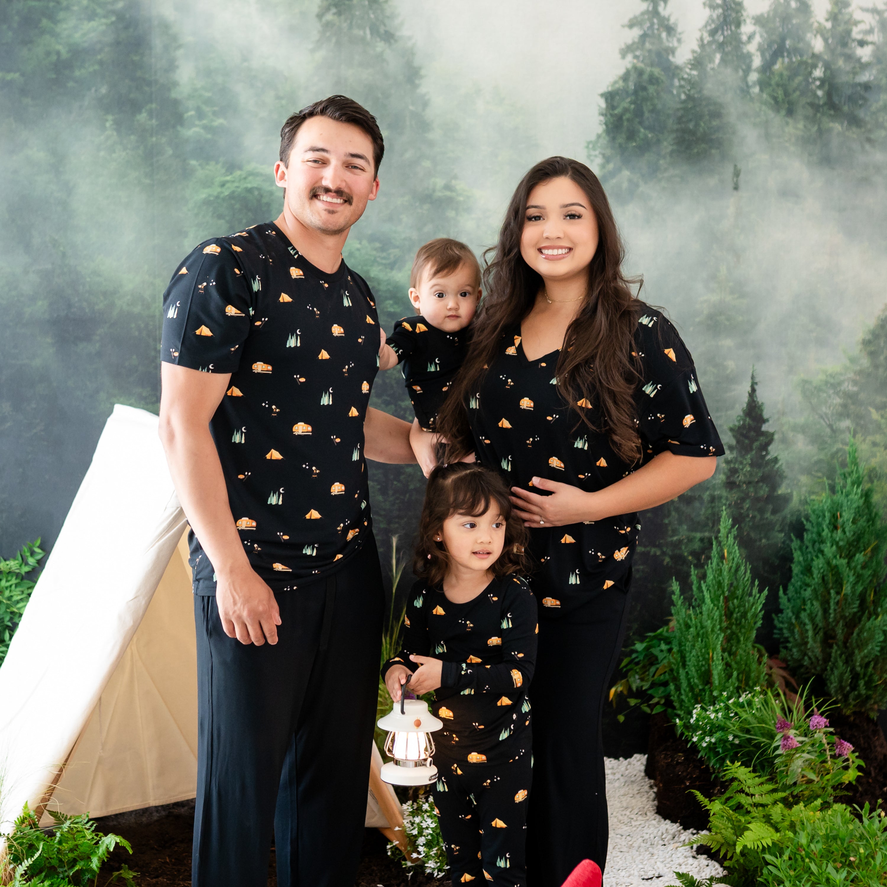 Family wearing the Under the Stars collection. Father is wearing the Men's Crew neck, Mother is wearing the Women's Relaxed V-Neck while the children are in toddler pajama sets