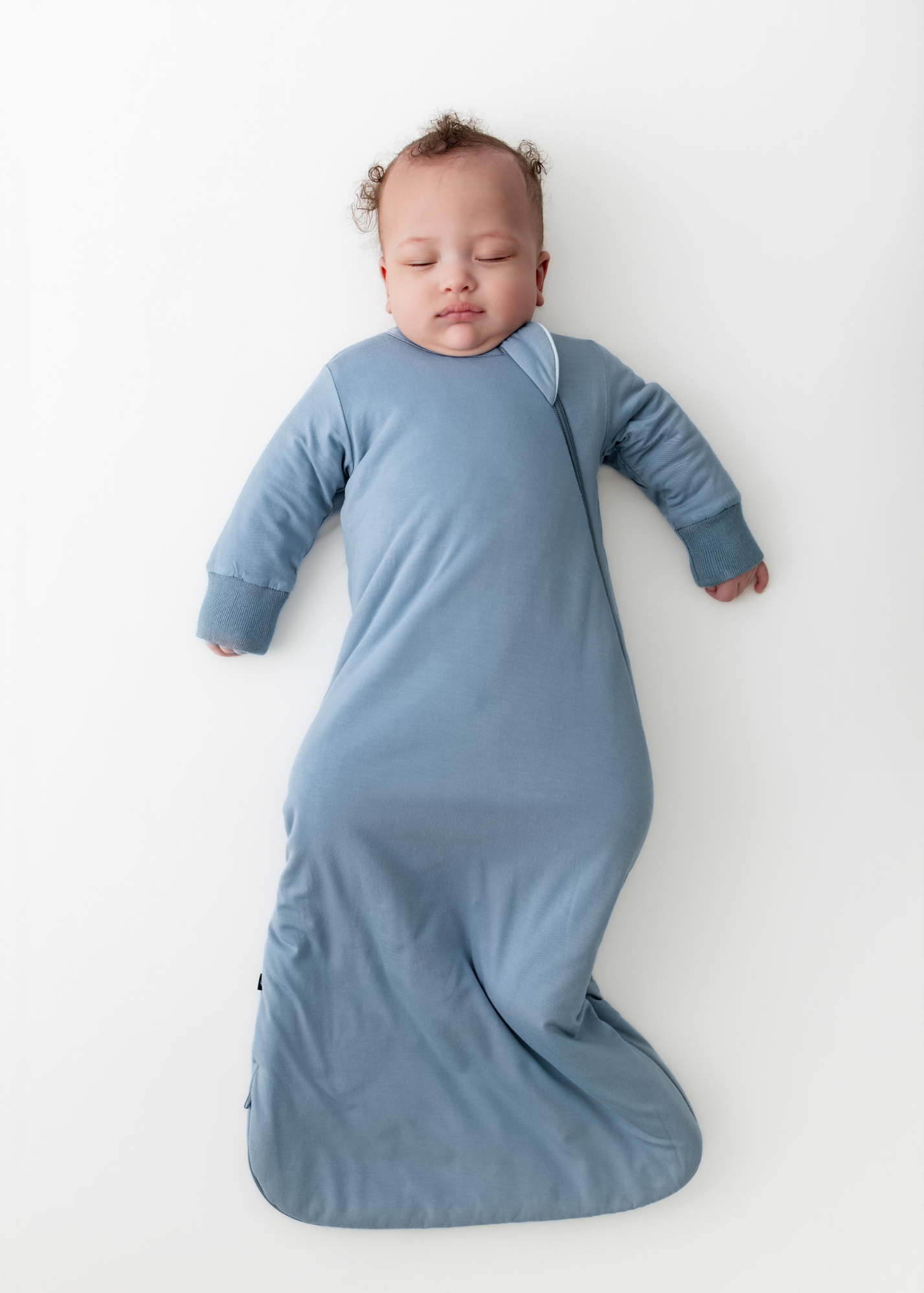 Baby asleep in a blue slumber bag