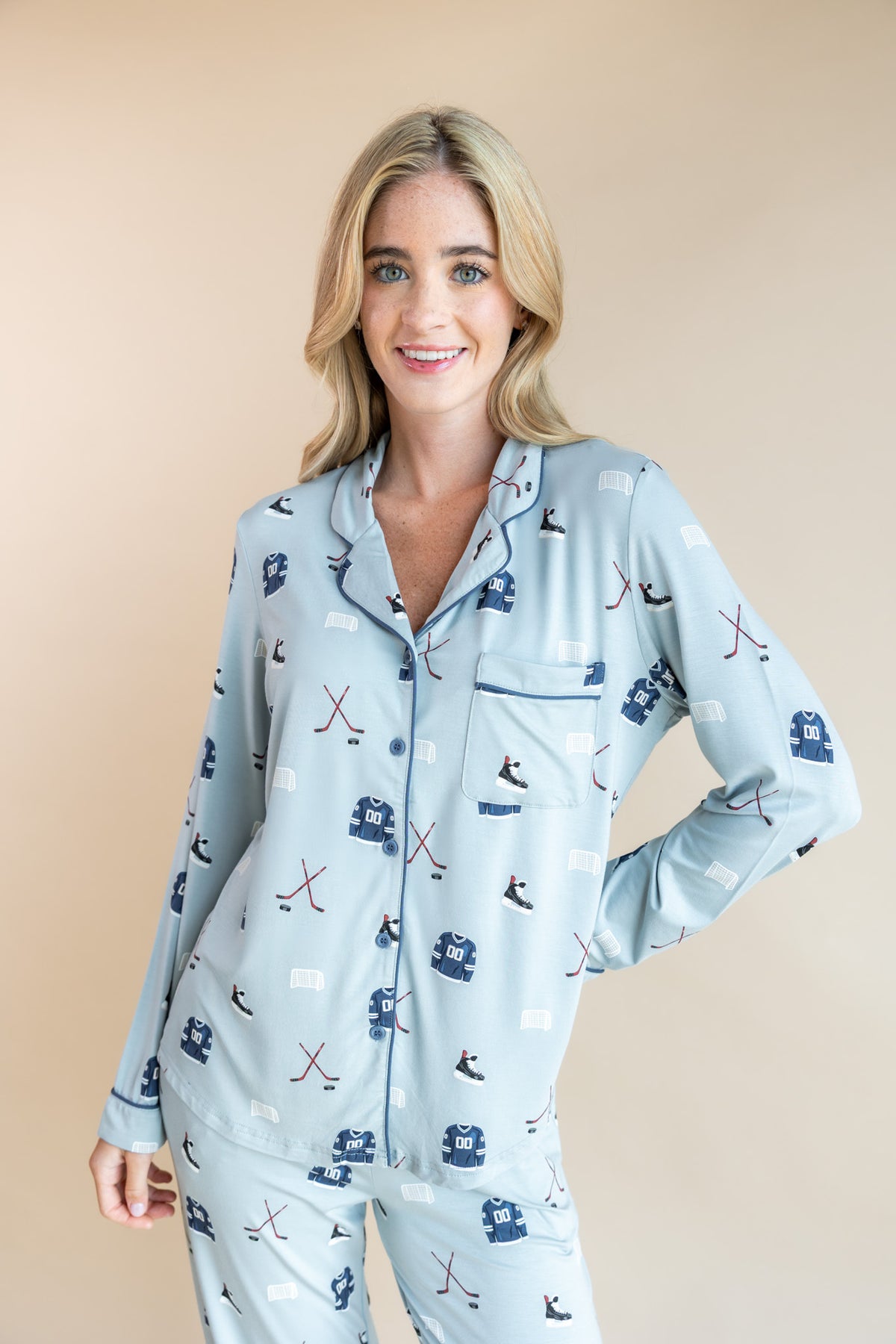 Modal posing in Blue Long-Sleeved Women's Pajama Set with Vintage Hockey print on a beige background