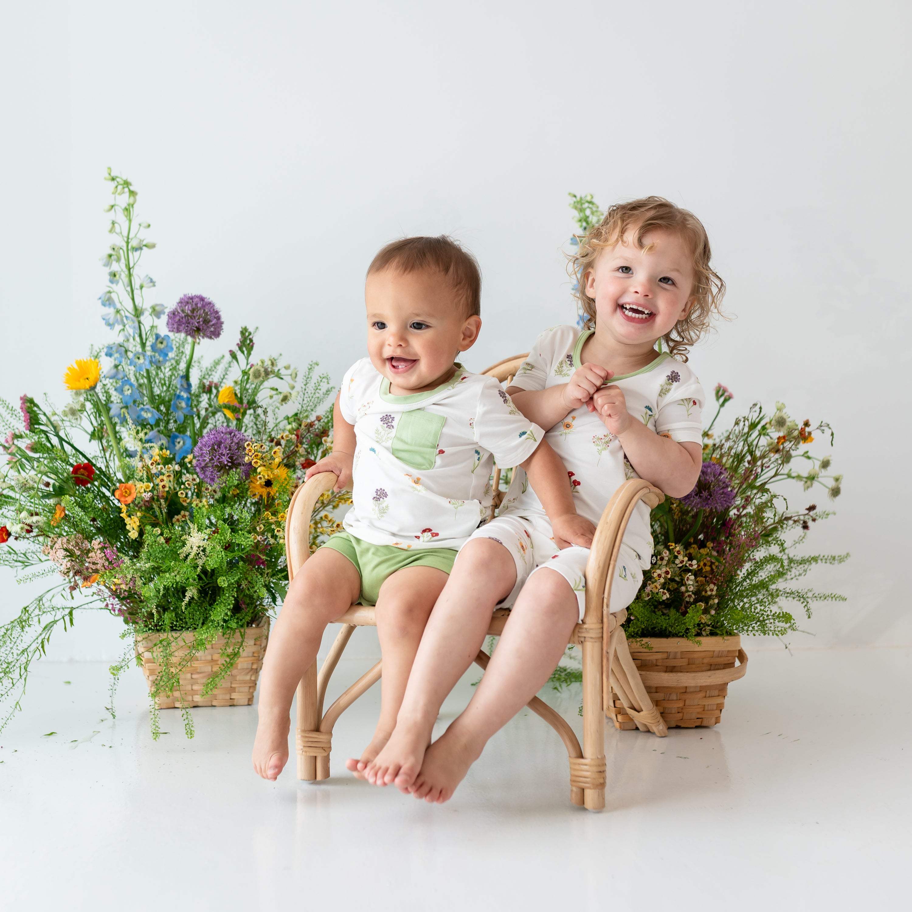 Toddler wearing Toddler Crew Neck Tee in Wildflower and Honu Bummies next to Toddler wearing Wildflower Short Sleeve Pajamas