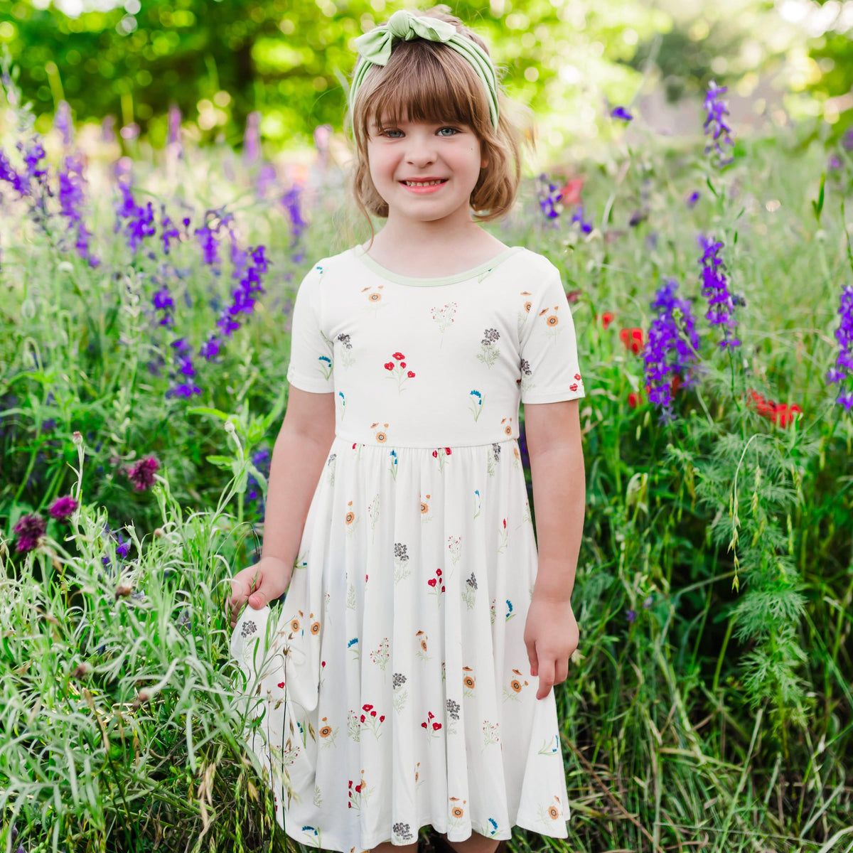 Child modeling Twirl Dress in Wildflower in a wildflower field