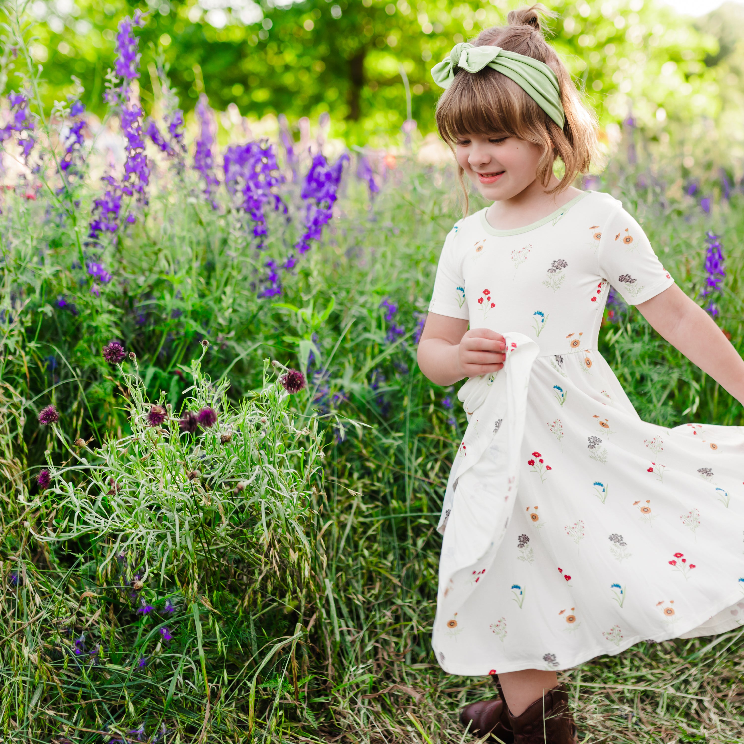 Child modeling Twirl Dress in Wildflower in a wildflower field twirling dress