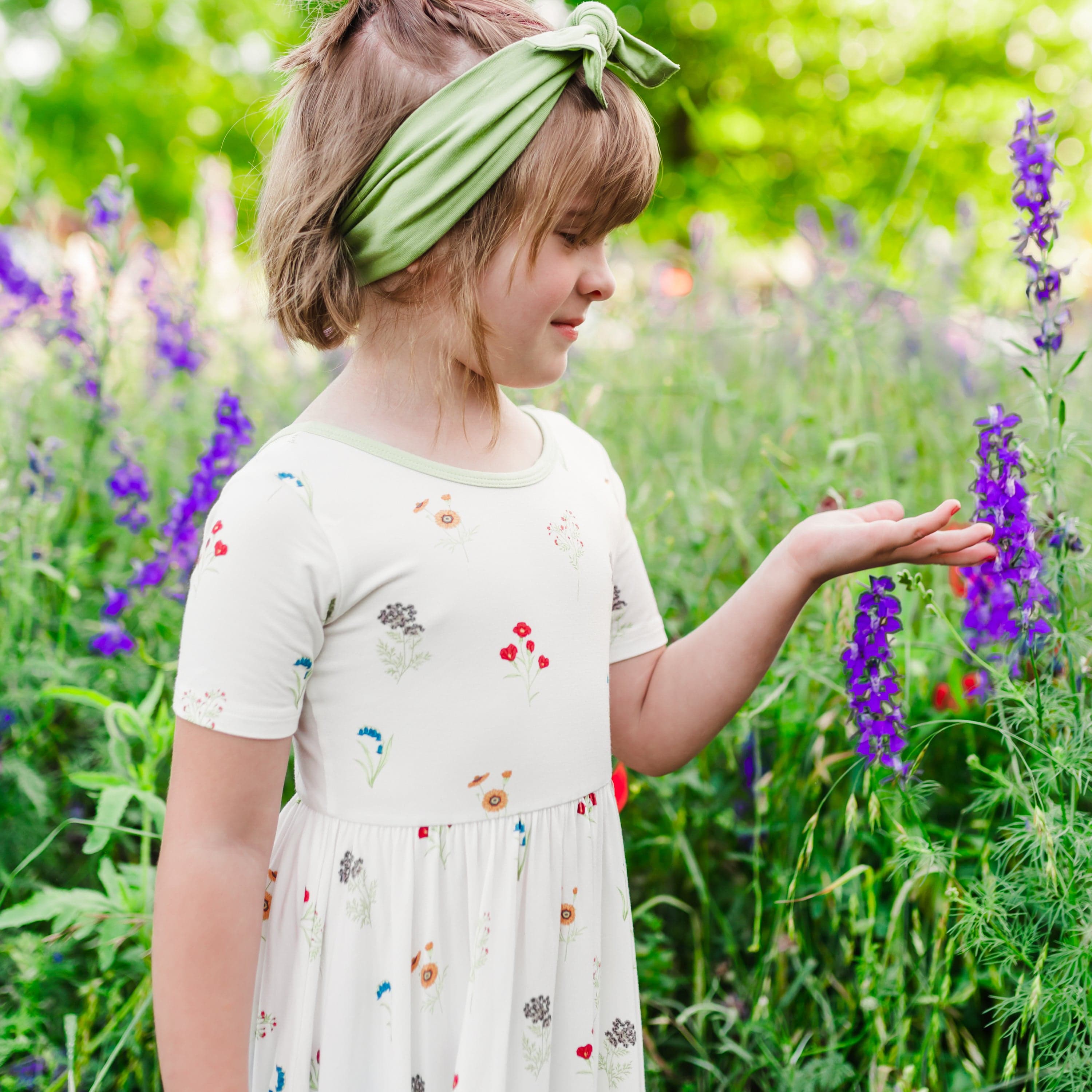 Close up of Child modeling Twirl Dress in Wildflower in a wildflower field