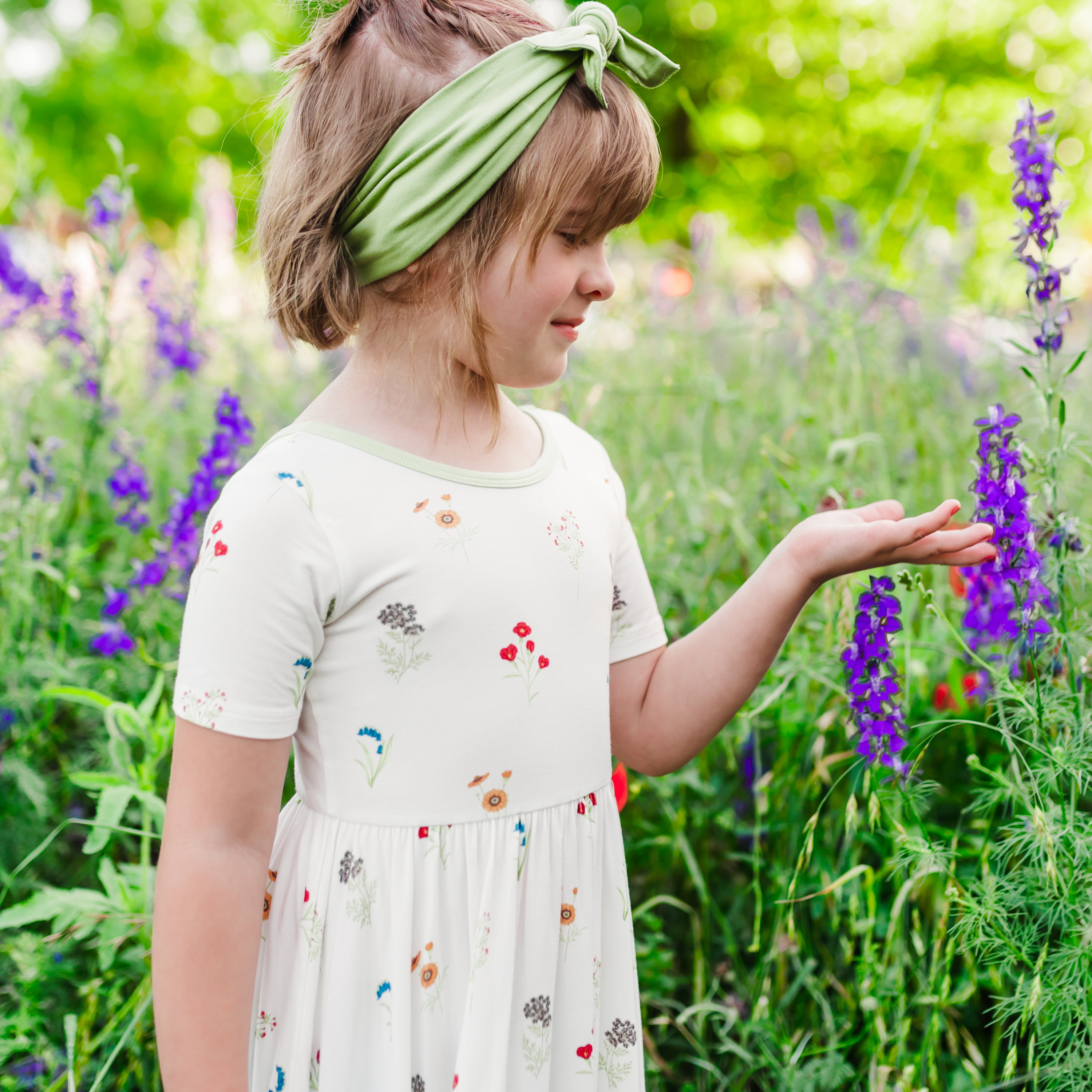 Close up of Child modeling Twirl Dress in Wildflower in a wildflower field