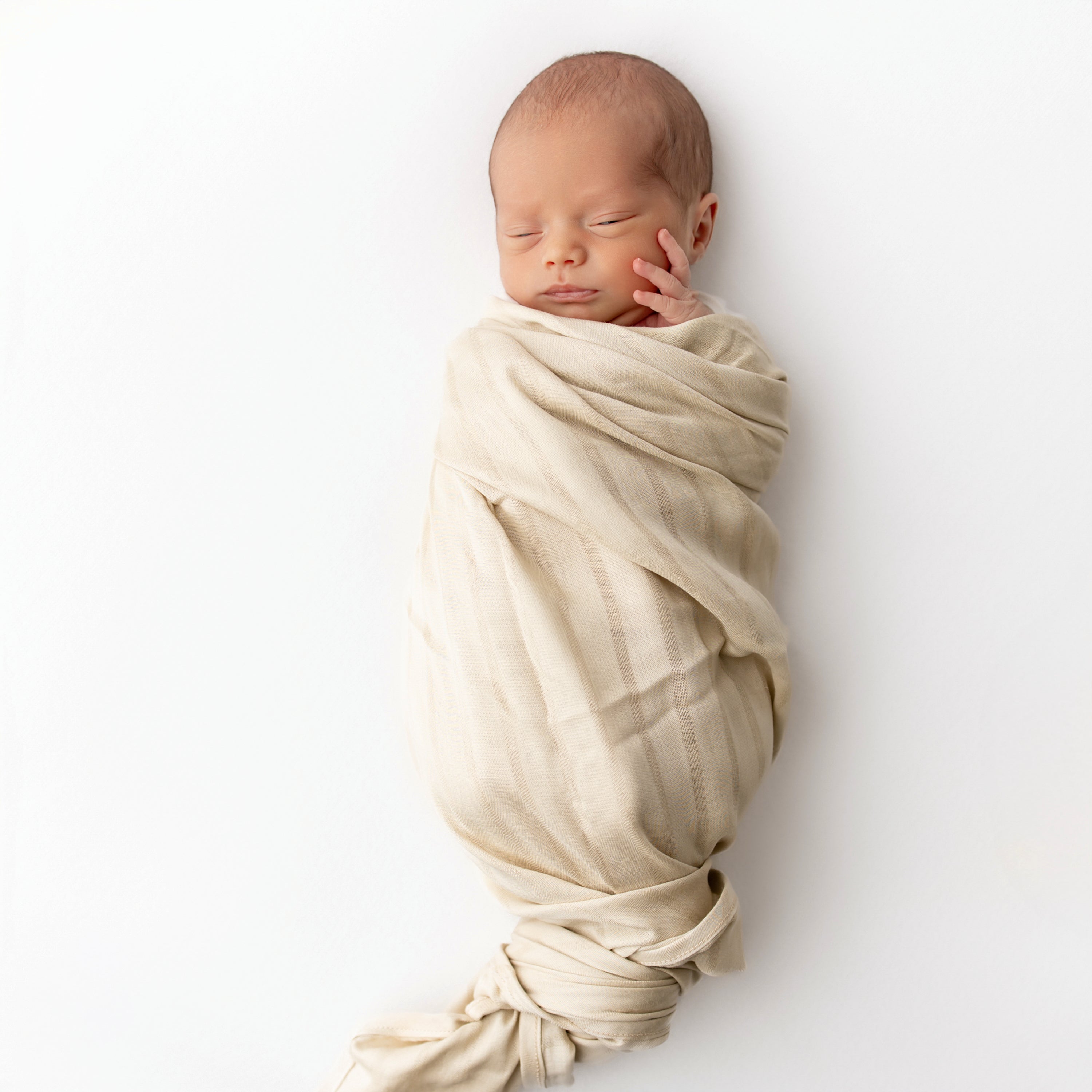Newborn wrapped in Bamboo Muslin Swaddle Blanket in Wheat