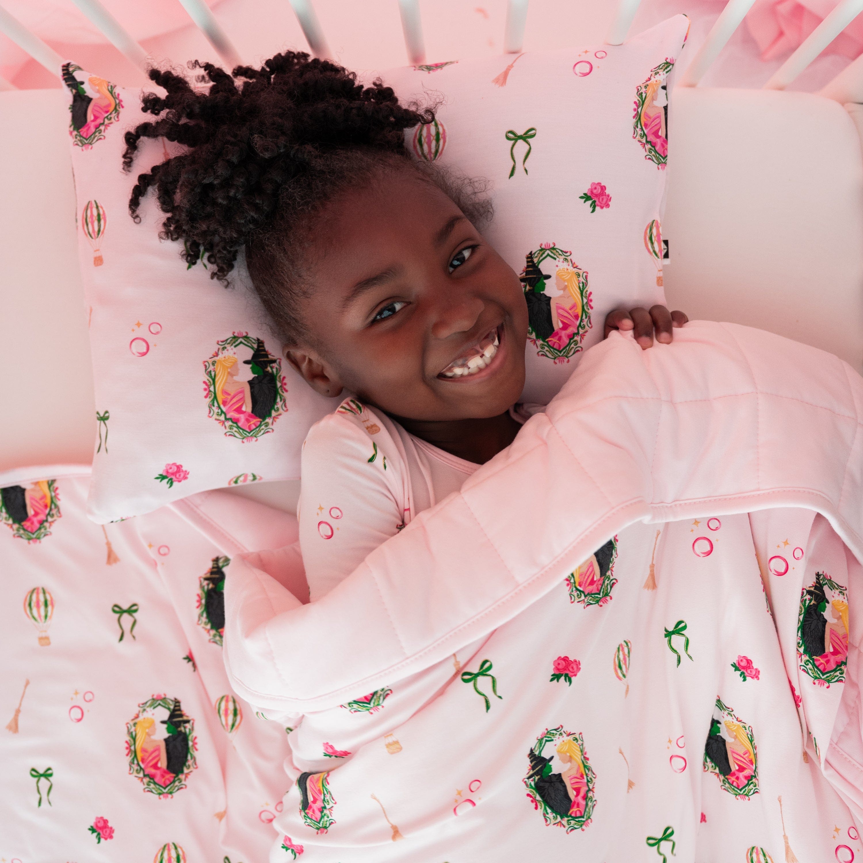 Young girl laying in bed with her head on the breathable Toddler Pillowcase in Wicked with the Youth Blanket in Wicked on top of her