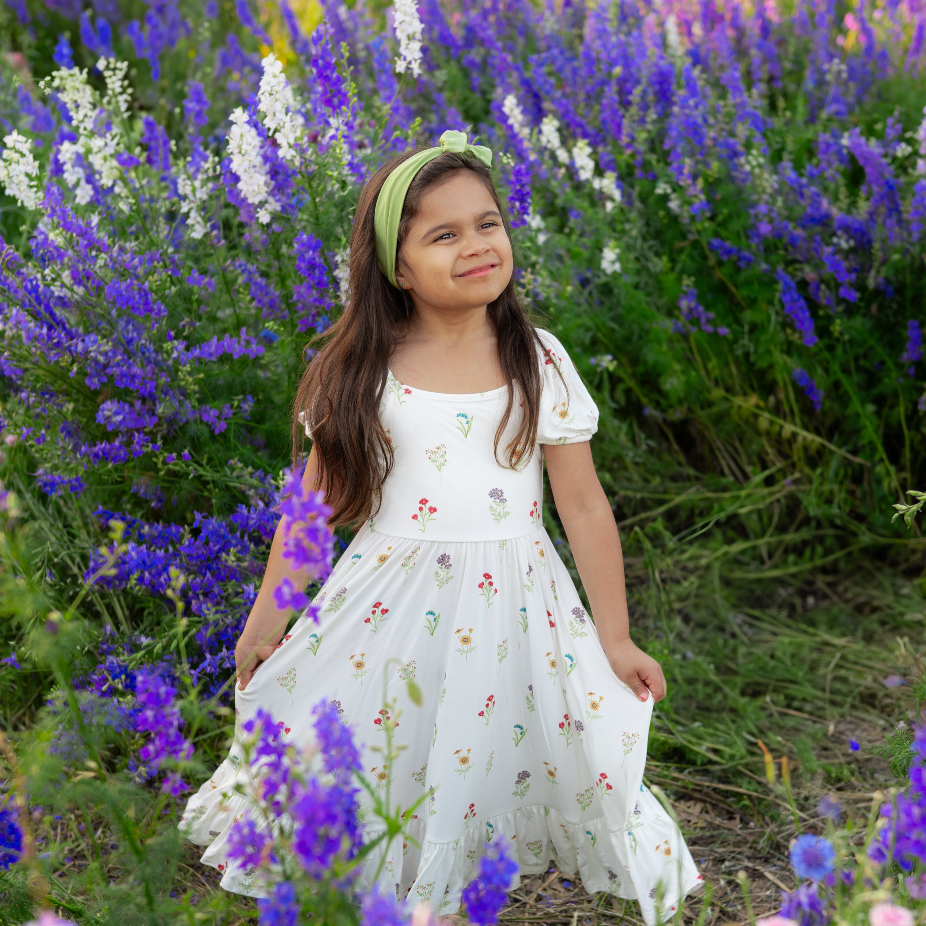 Child modeling Puff Sleeve Twirl Dress in Wildflower in a field of purple flowers