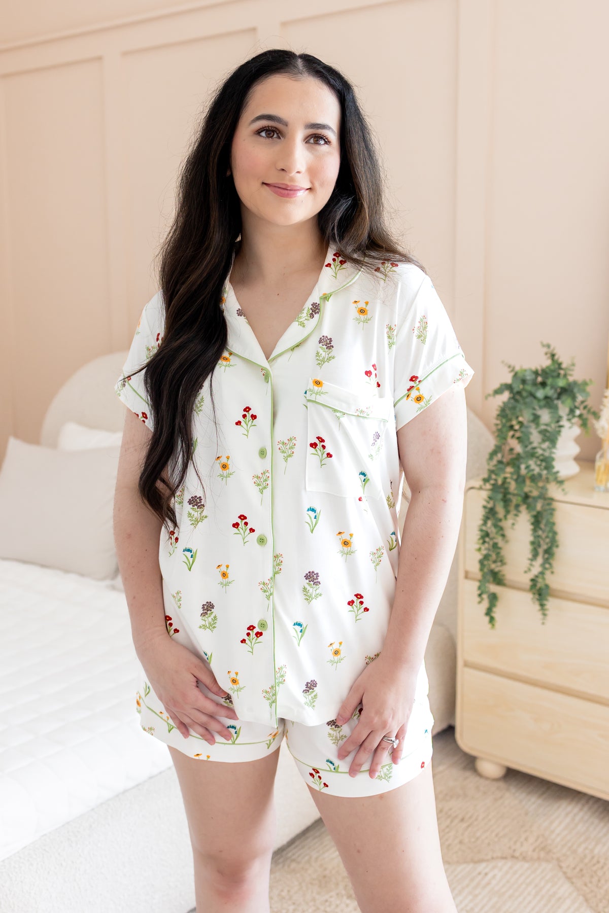 Woman wearing a floral pajama set in a bedroom setting
