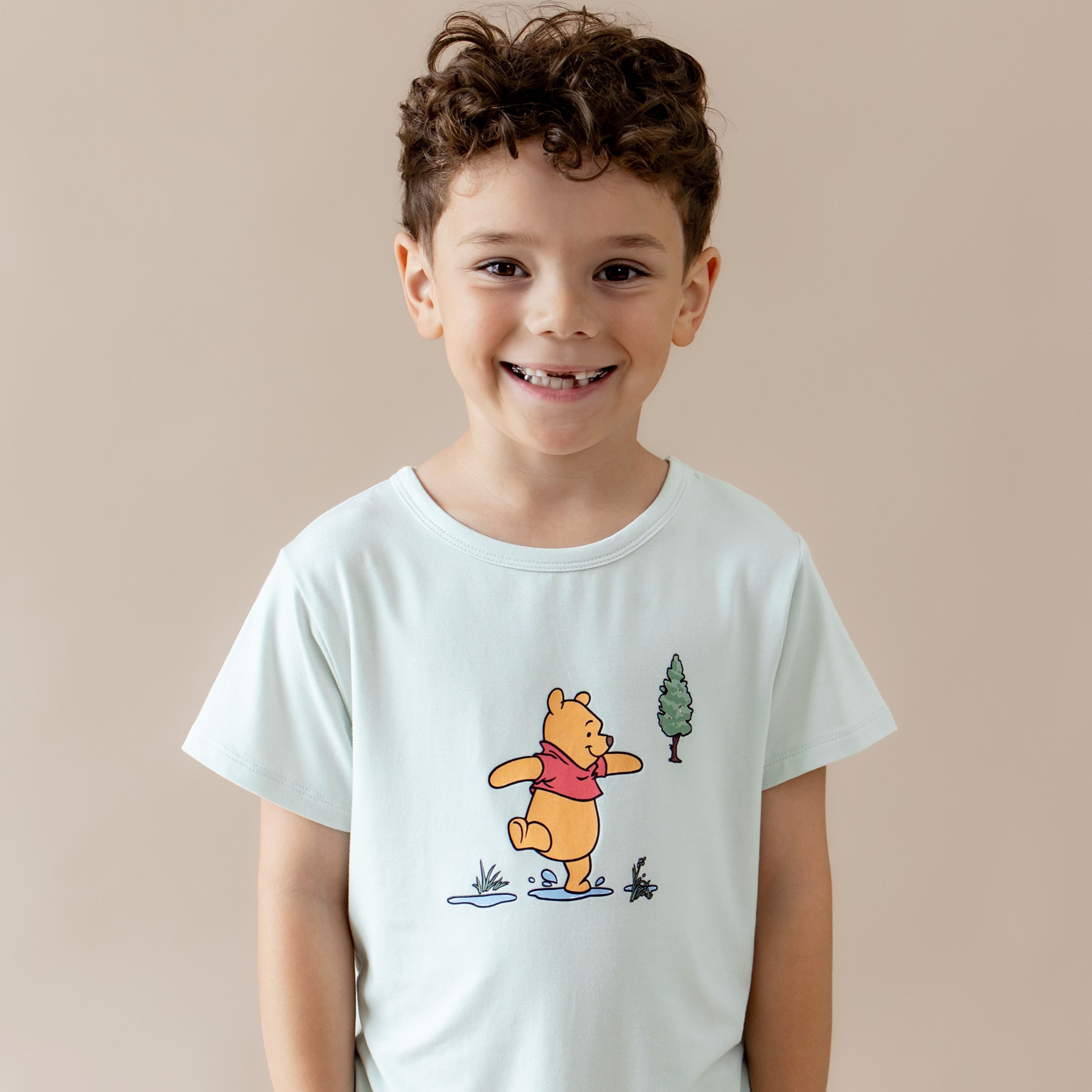 Close up of smiling boy wearing the Toddler Basic Tee in Winnie the Pooh on Dew