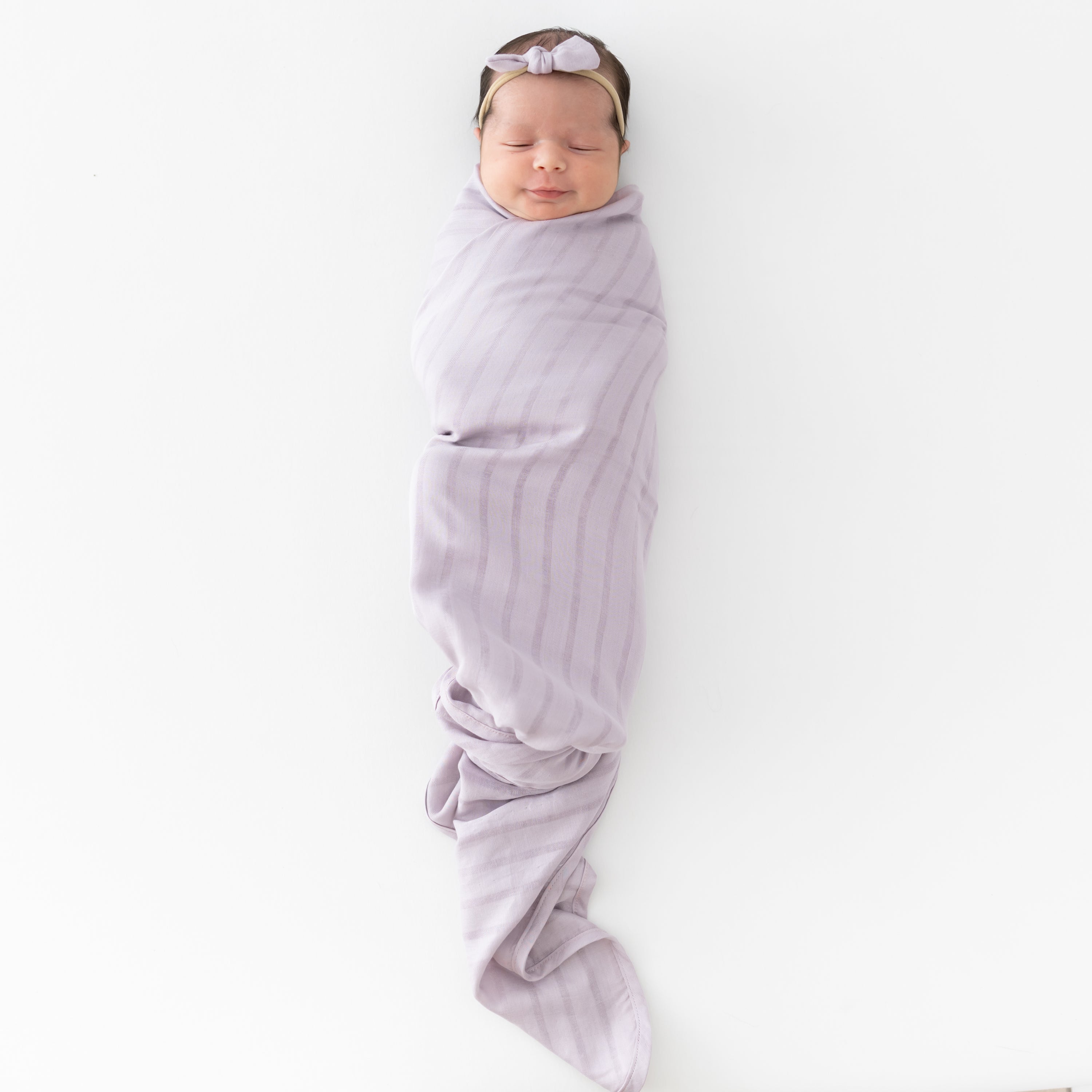 Newborn wrapped in Bamboo Muslin Swaddle Blanket in Wisteria