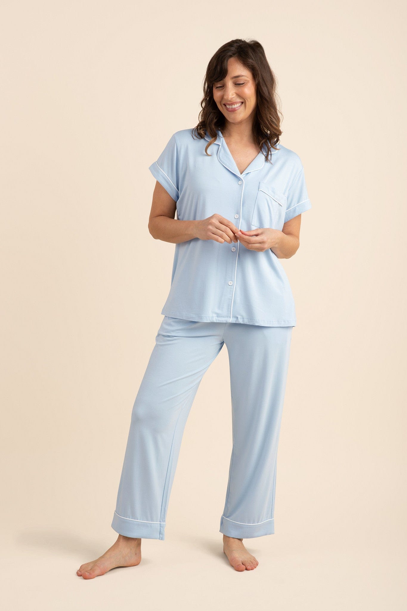 Smiling model wearing the Women's Short Sleeve Cropped Pajama Set in Breeze standing in front of a light beige background