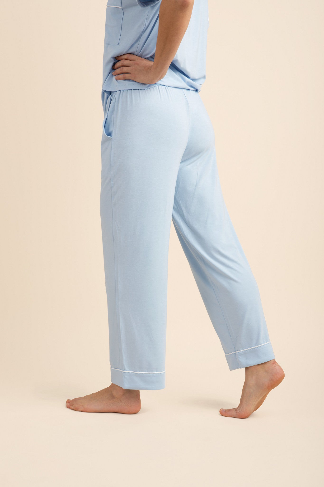 Female model wearing the Women's Short Sleeve Cropped Pajama Set in Breeze facing away from the camera showing the back of the pants