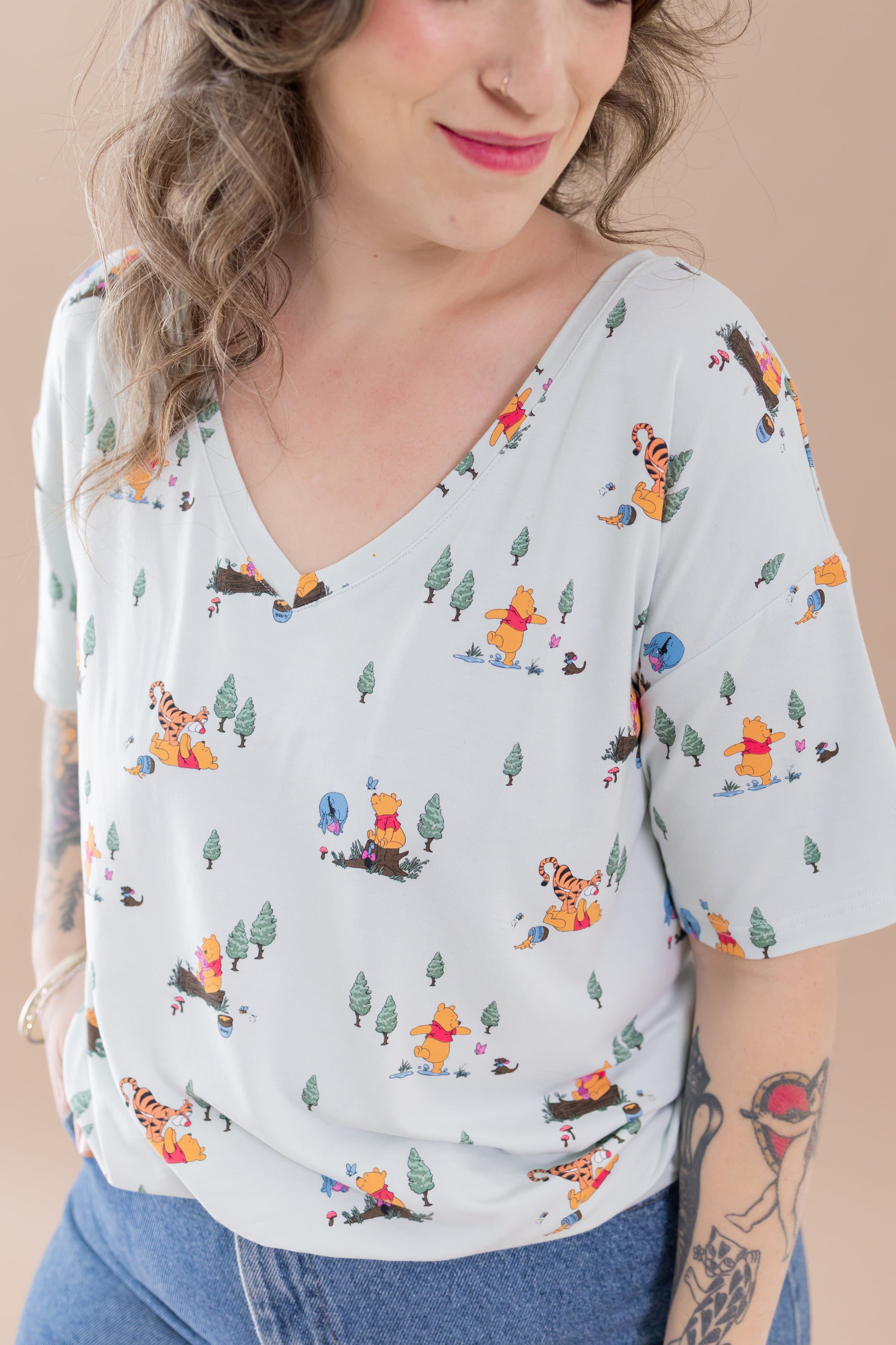 Close up of a female model wearing the Women's Relaxed Fit V-Neck in Winnie the Pooh Hundred Acre Wood