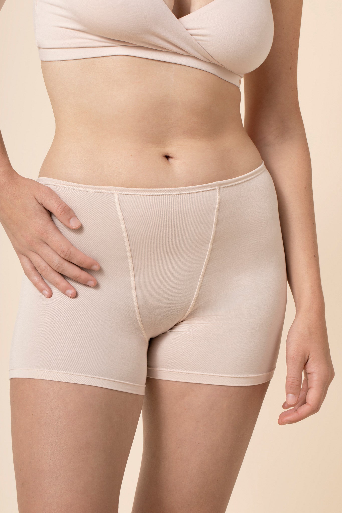 Beige boxer short worn by a person on a beige background