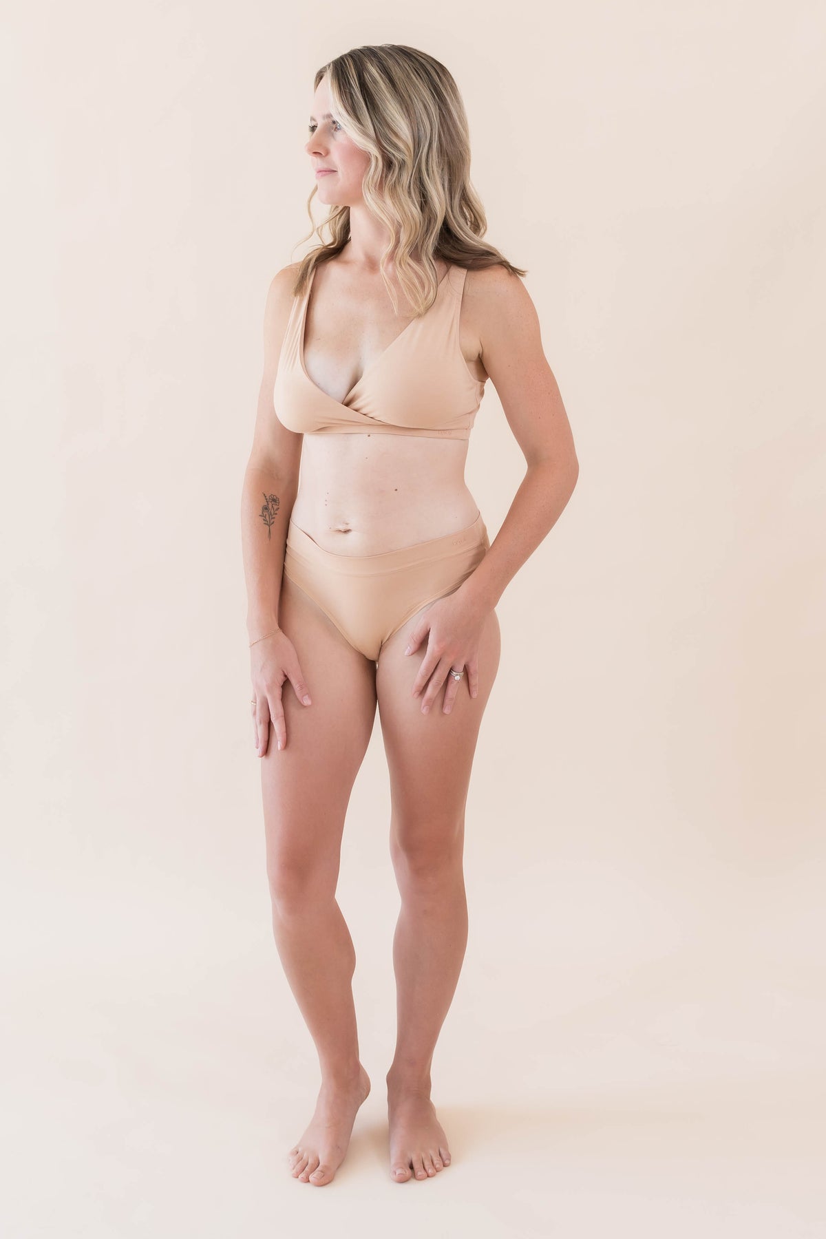 Model posing wearing the Women's Cross Front Bralette in Chai with matching underwear