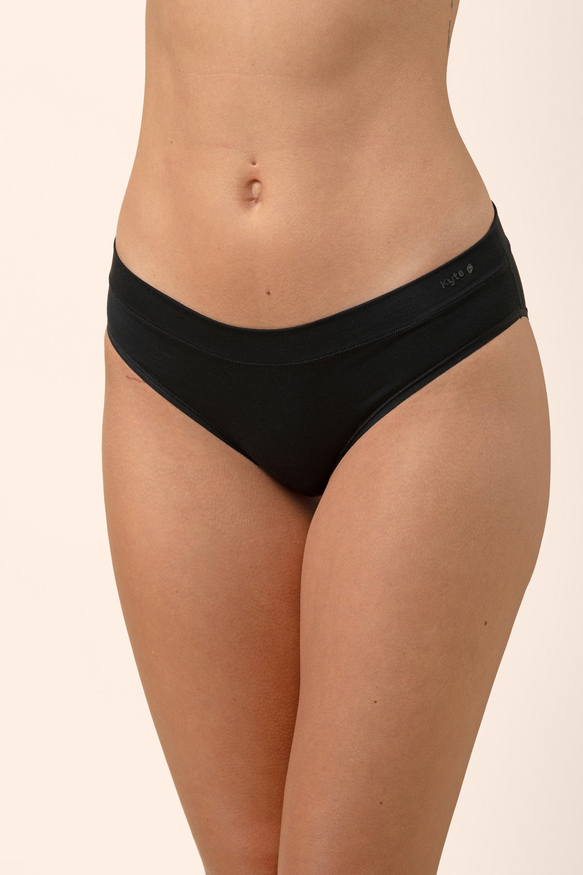Black bamboo underwear worn by a female on a beige background