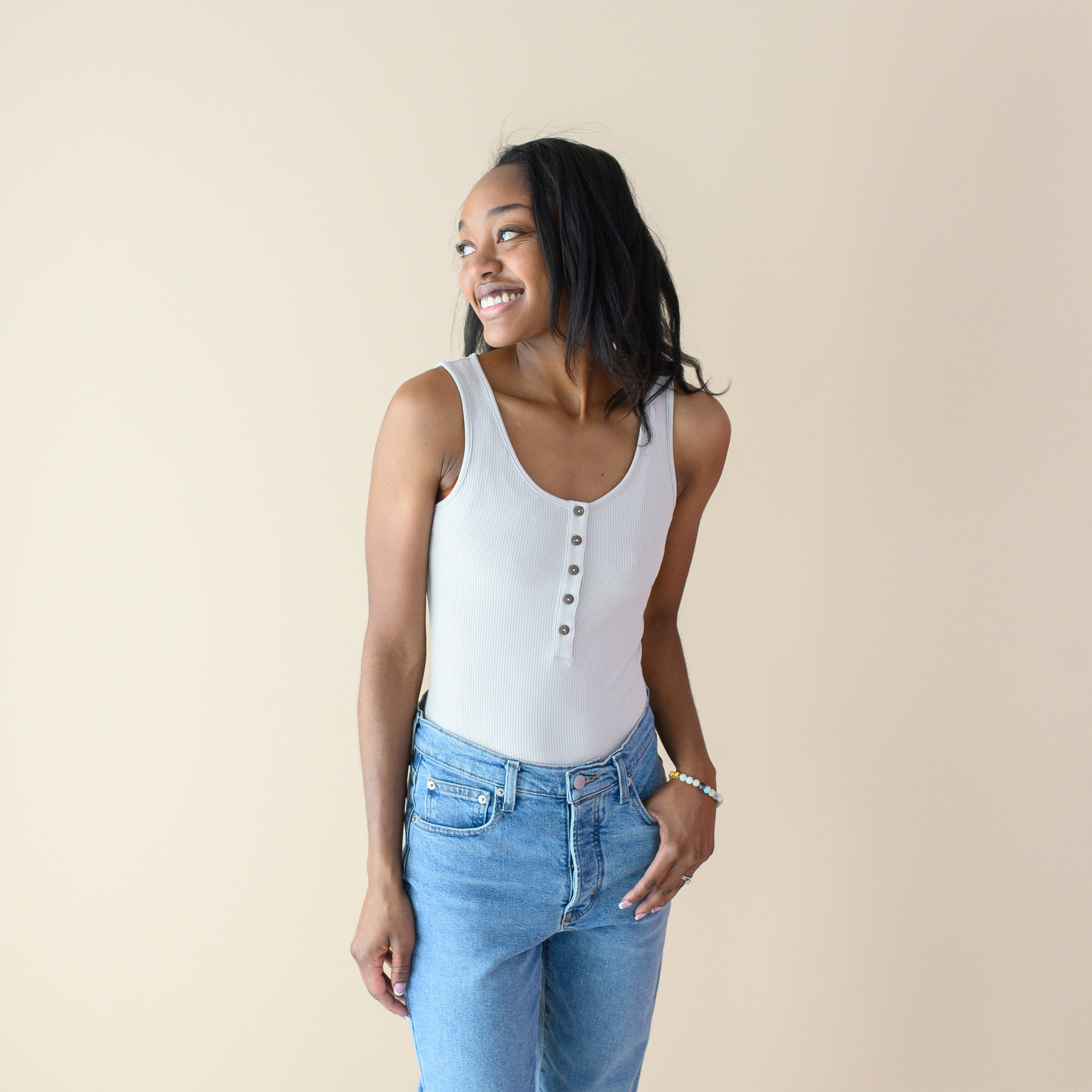 Woman wearing Women’s Ribbed Henley Bodysuit in Oat with jeans