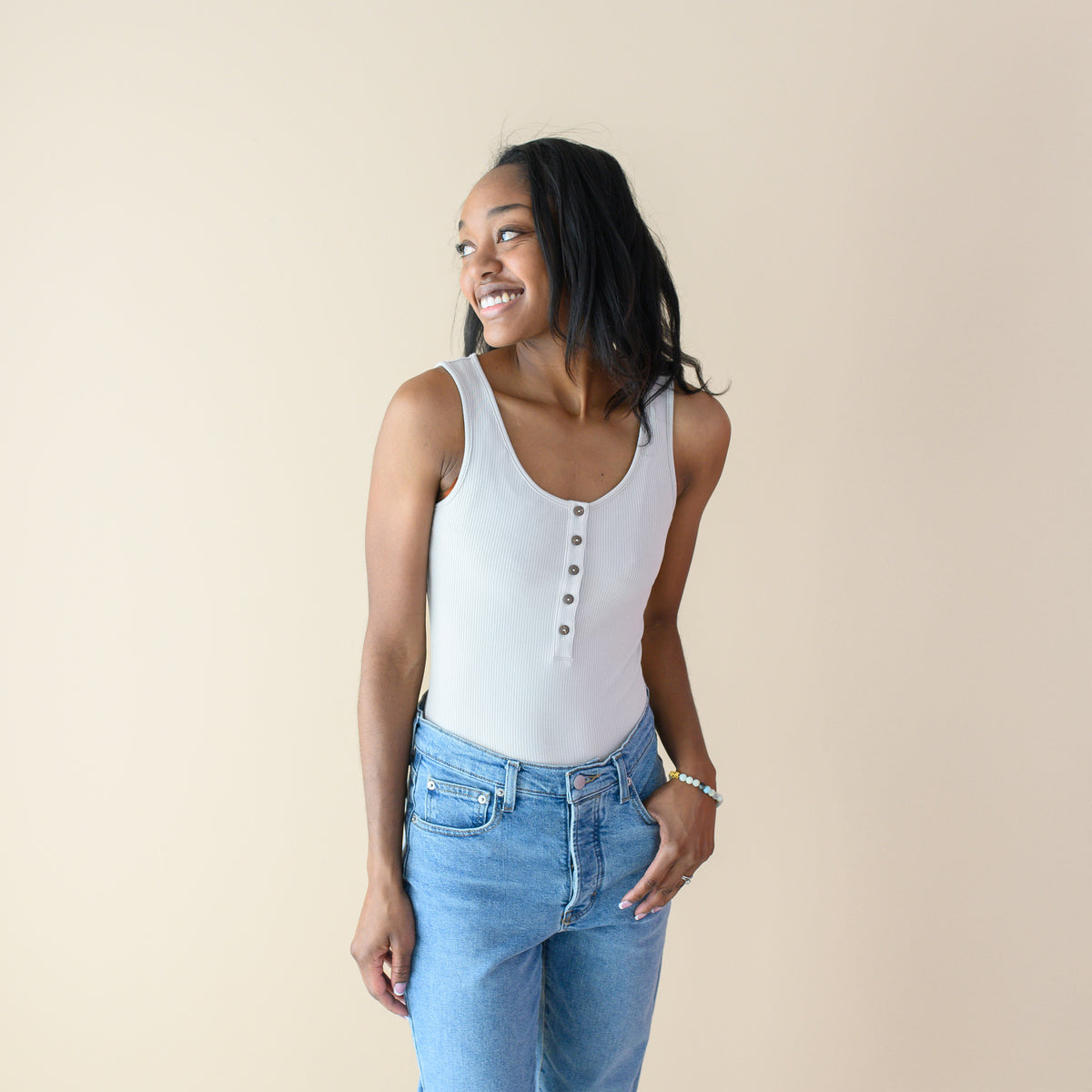 Woman wearing Women’s Ribbed Henley Bodysuit in Oat with jeans