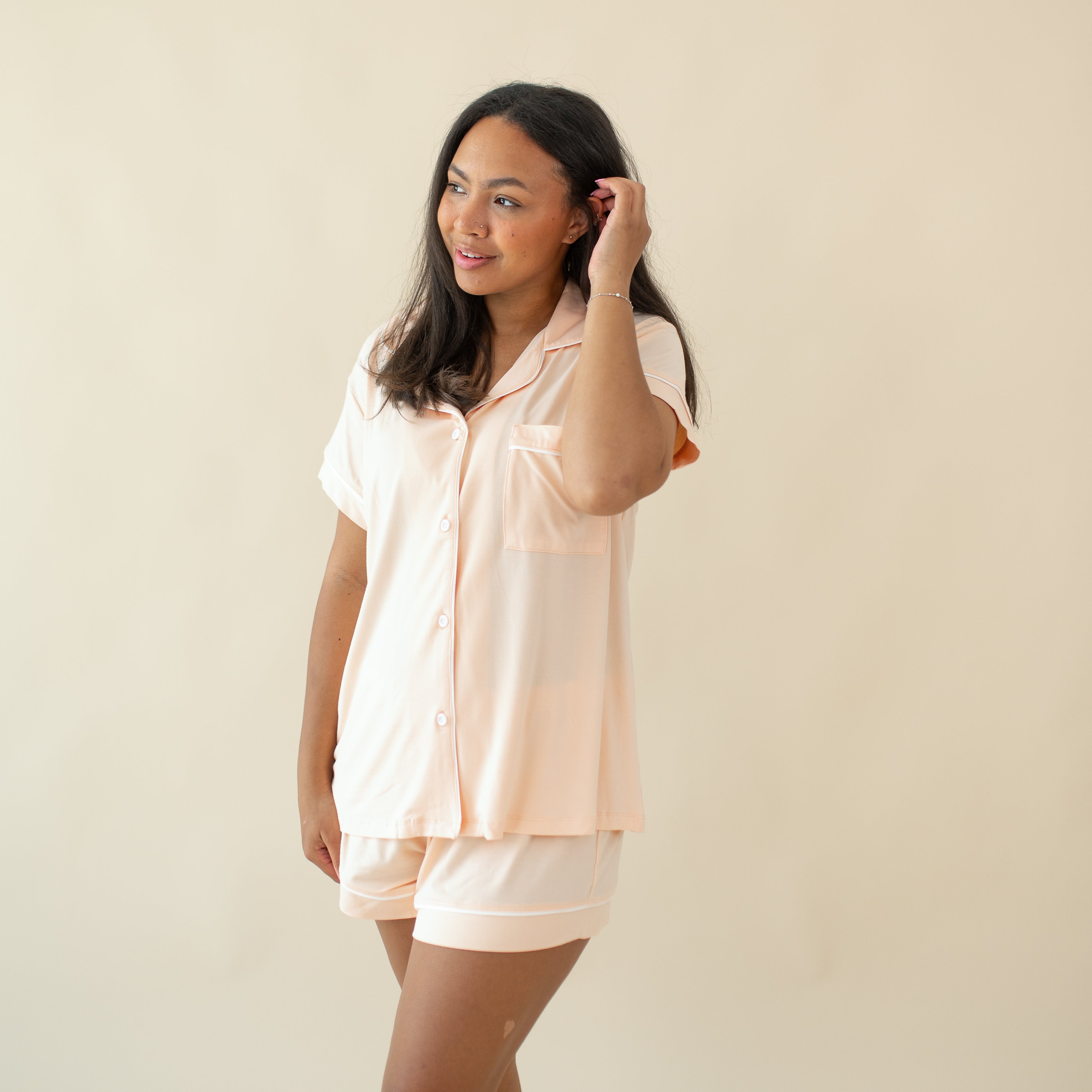 Model tucking hair behind her ear wearing the Women's Short Sleeve Pajama Set in Canyon