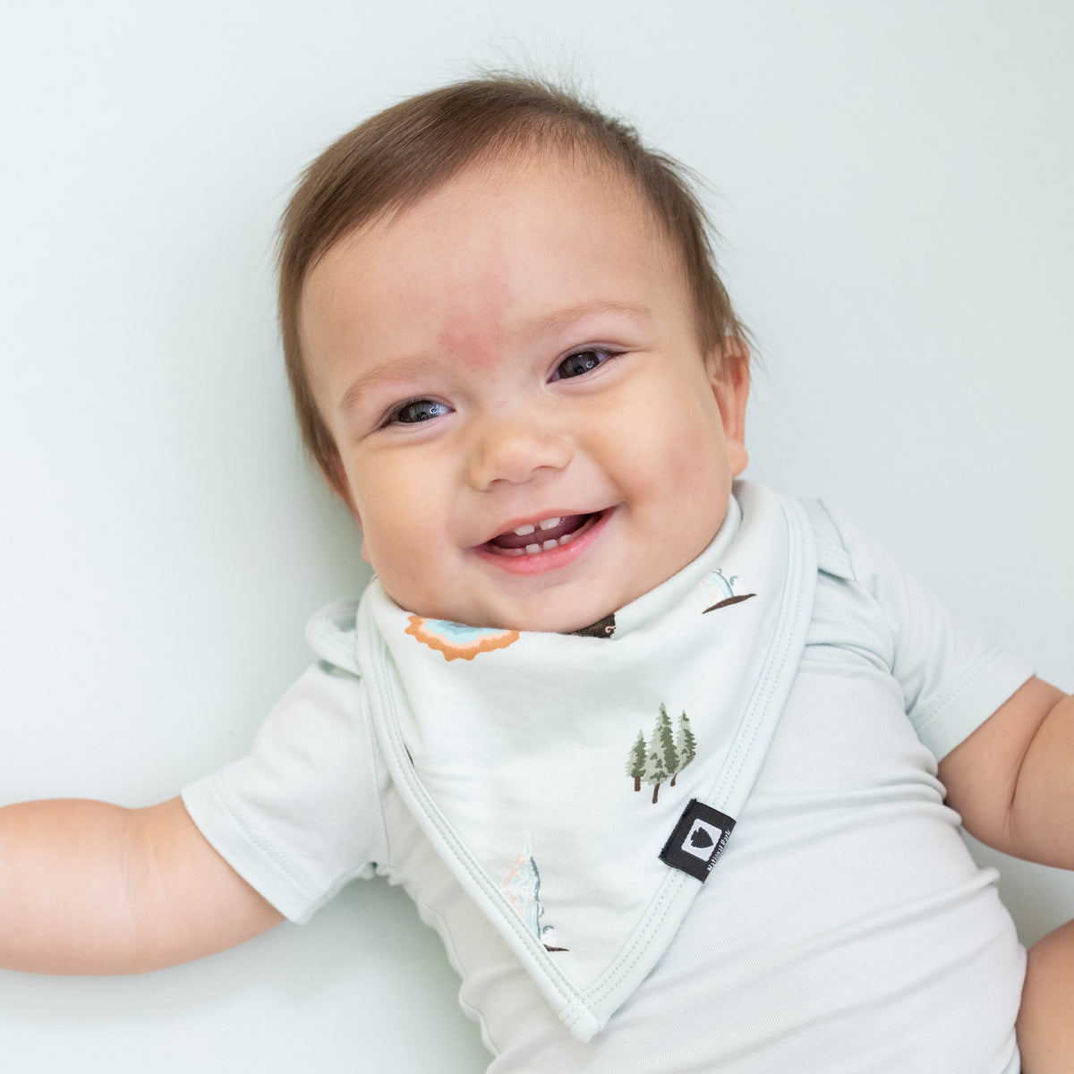Baby wearing Bib in Yellowstone and Dew bodysuit