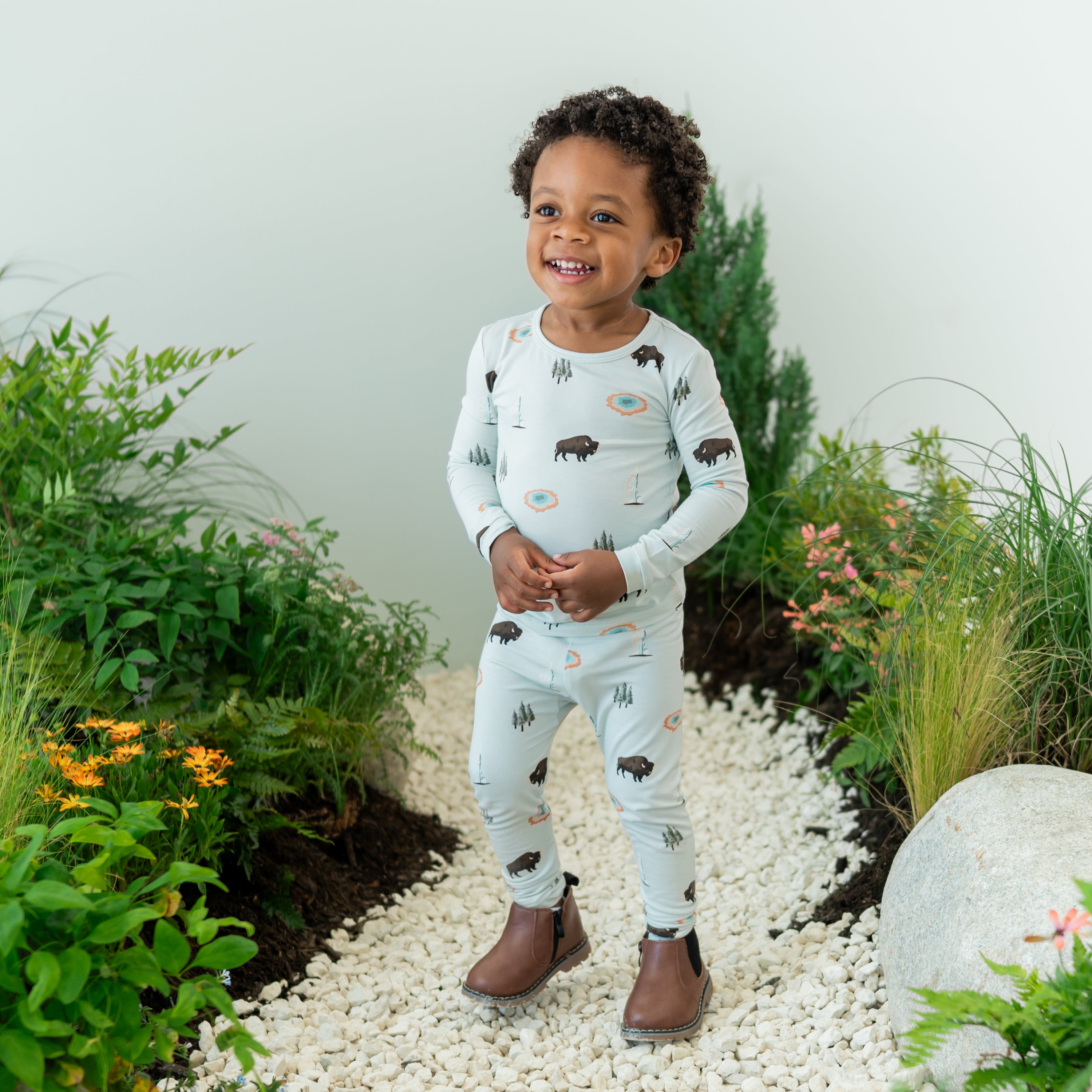 Toddler wearing Long Sleeve Pajamas in Yellowstone with a nature themed backdrop