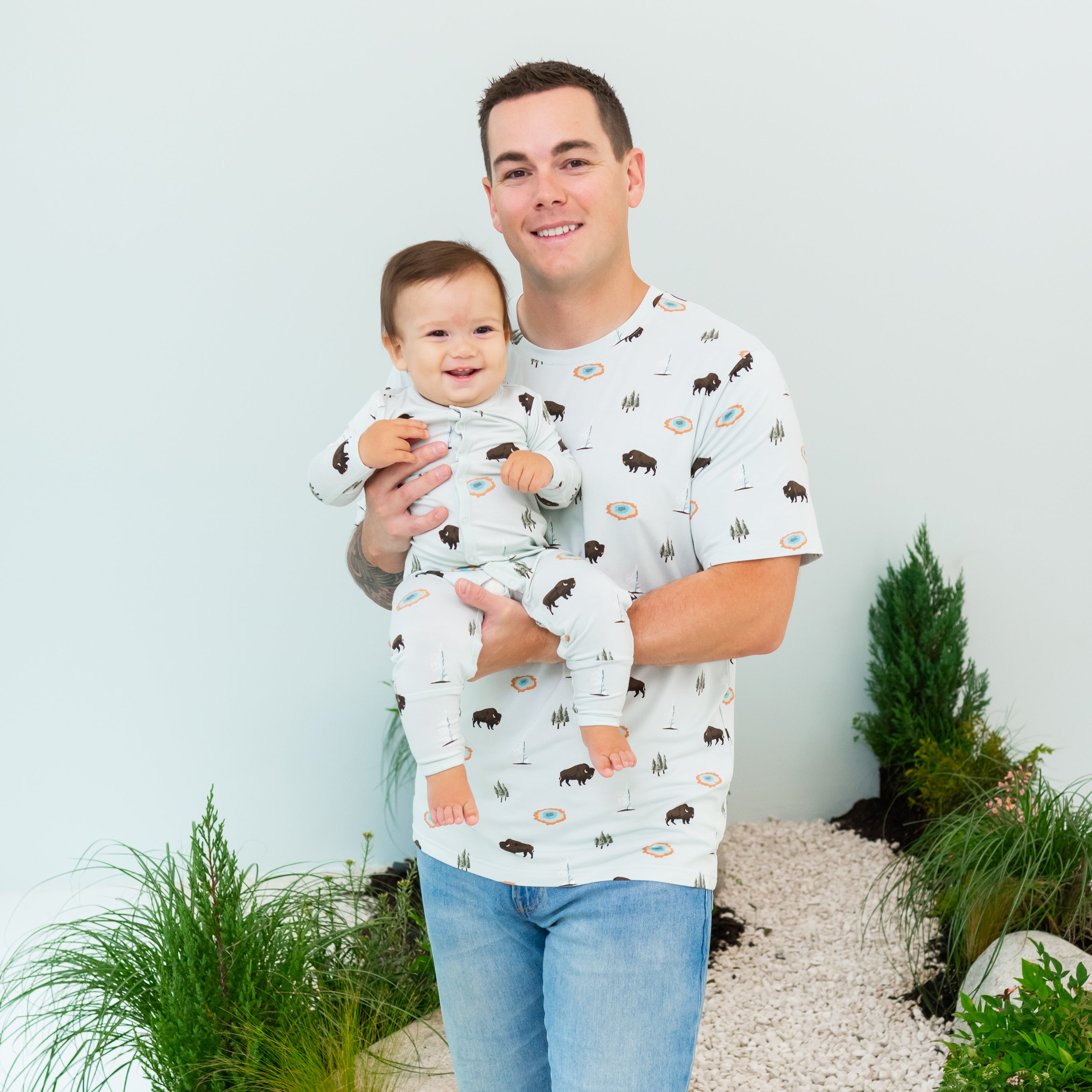 Man wearing Men's Crew Neck Tee in Yellowstone holding baby wearing Yellowstone Romper