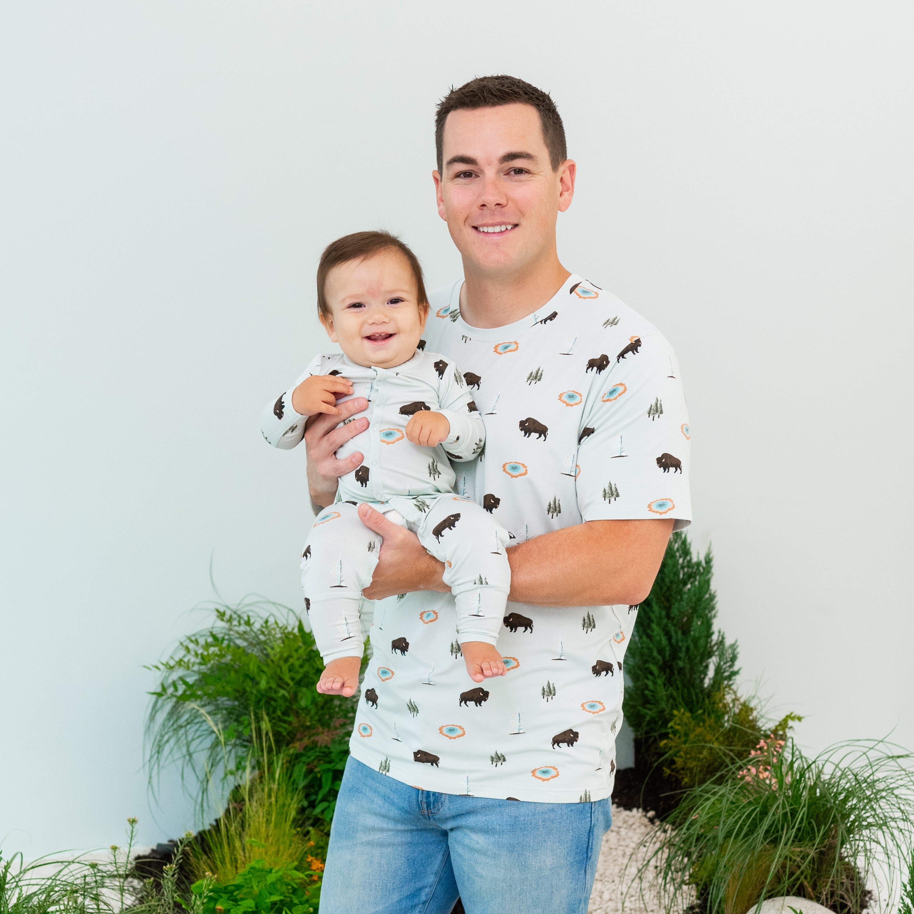 Dad holding baby wearing matching Daddy and Me outfits in Yellowstone print