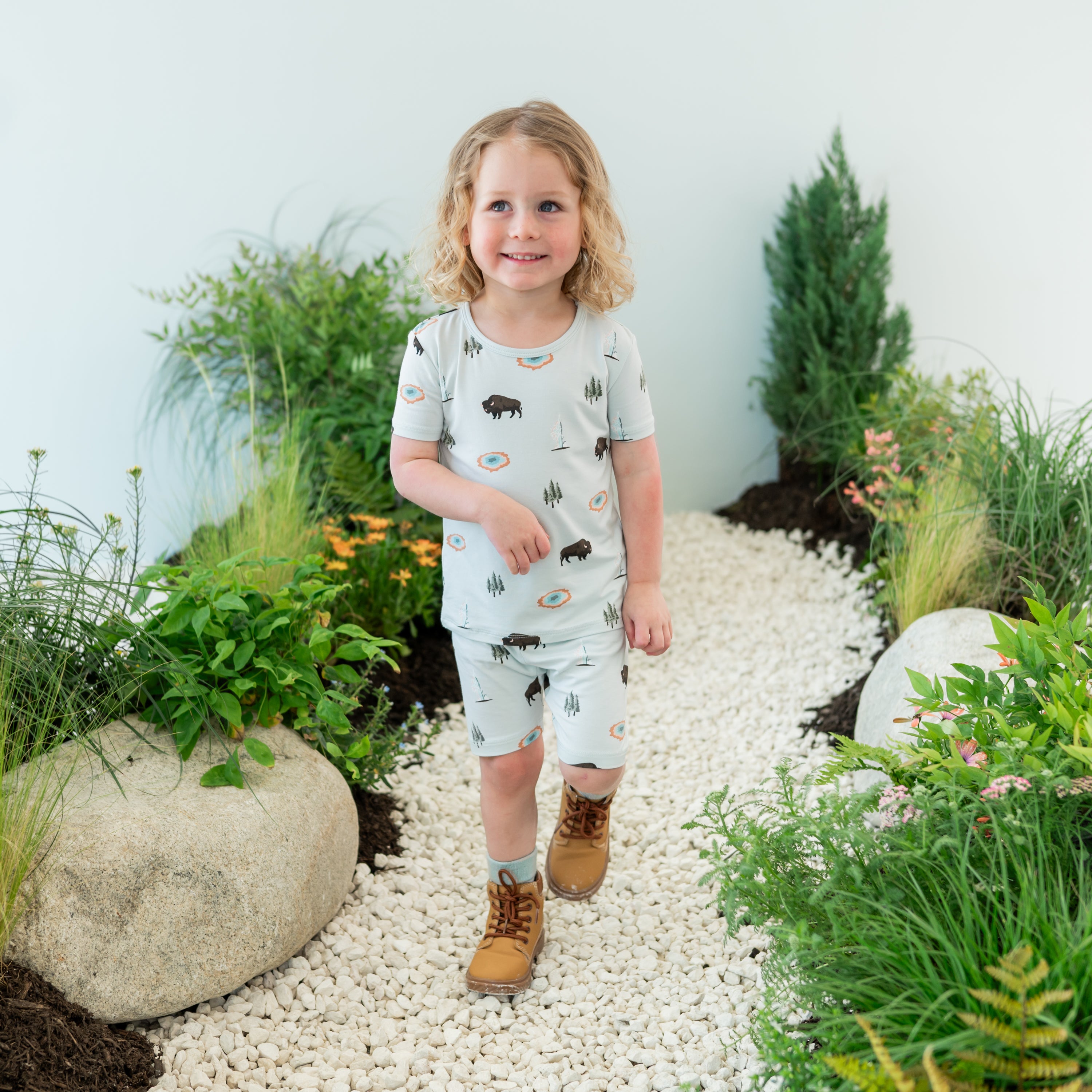 Toddler wearing Short Sleeve Pajamas in Yellowstone on a nature trail backdrop