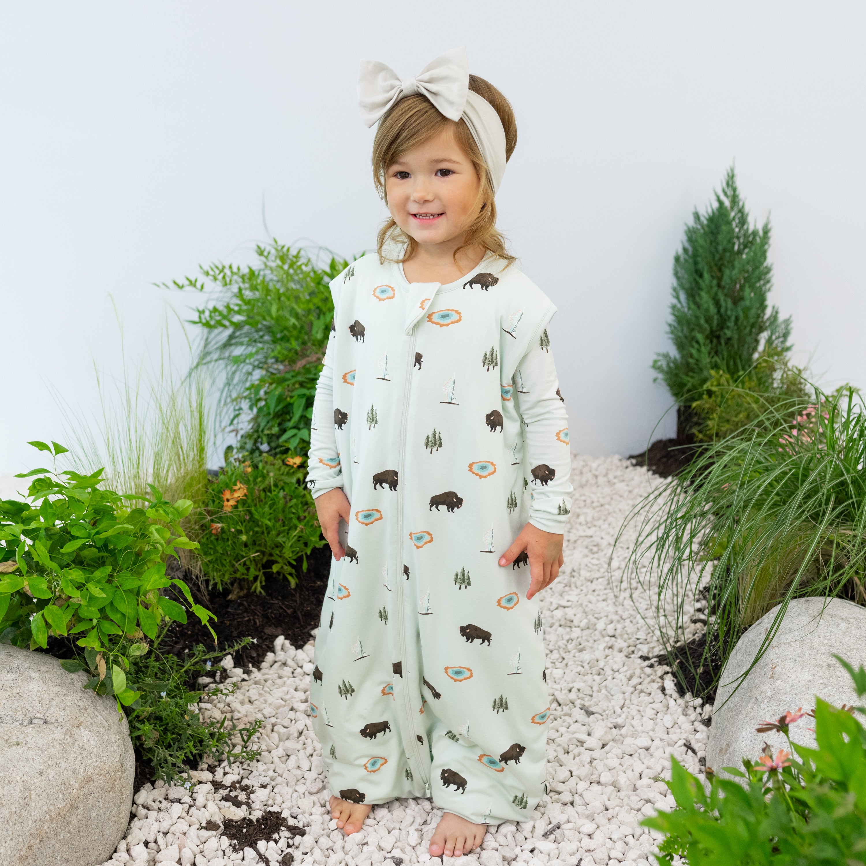 Toddler modeling Sleep Bag Walker in Yellowstone 1.0 on a nature trail backdrop