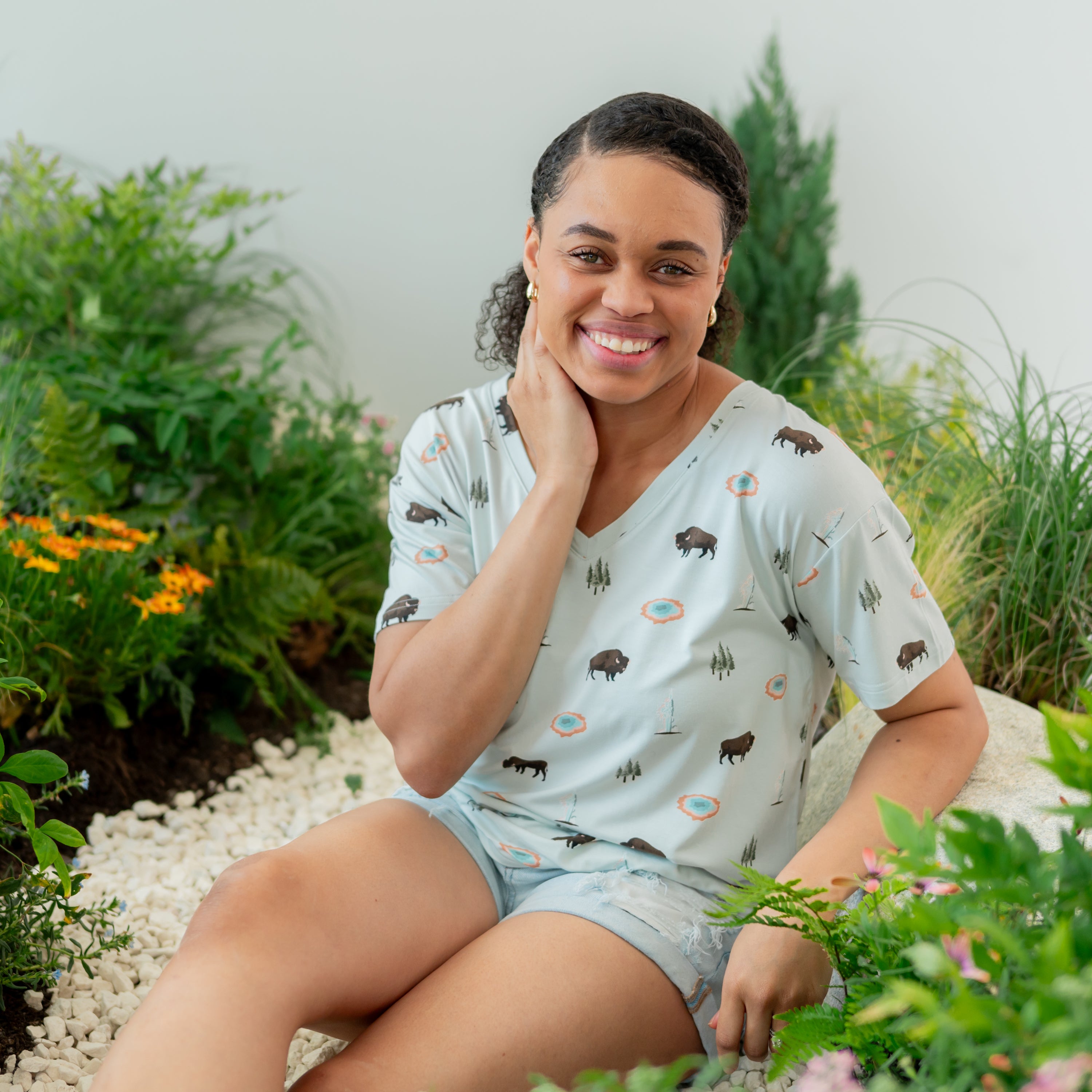 Woman wearing Women's Relaxed Fit V-Neck in Yellowstone with nature trail backdrop