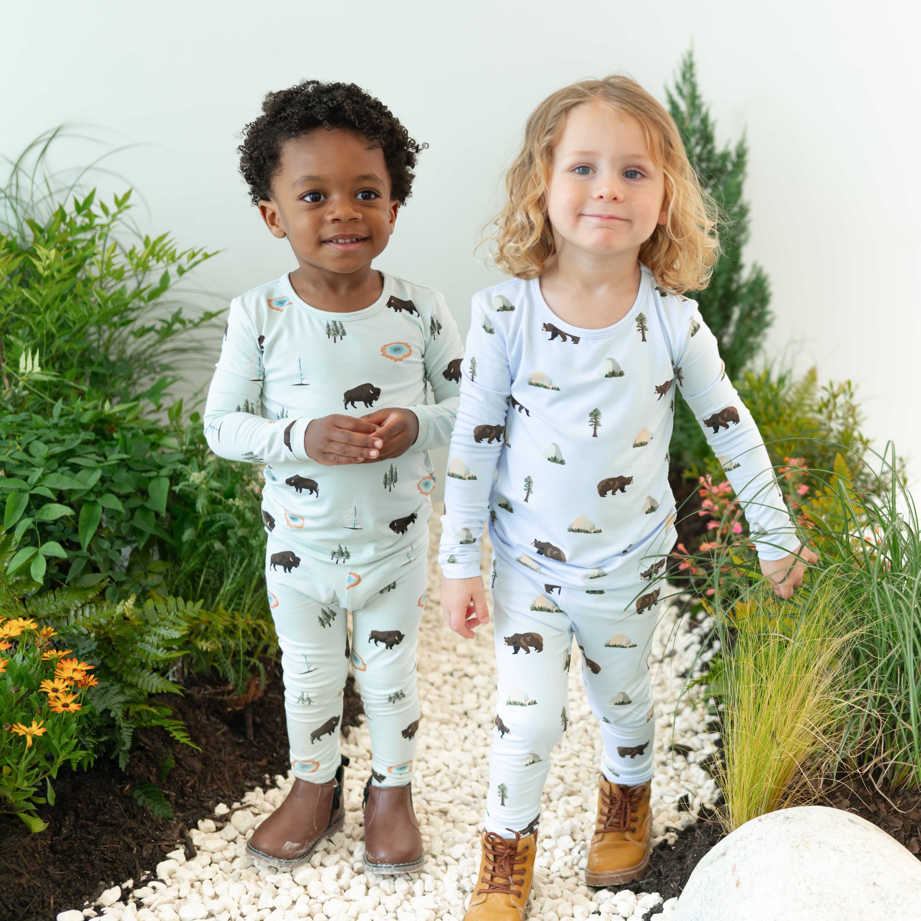 2 toddlers wearing Long Sleeve Pajamas in Yellowstone and Yosemite with a nature path background