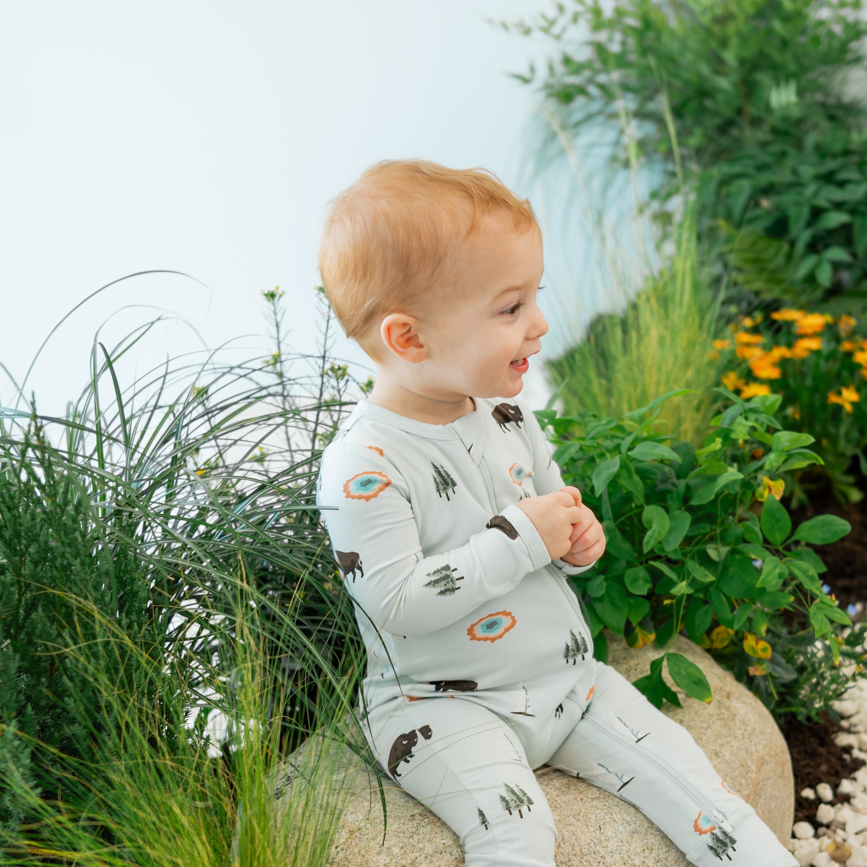 Toddler modeling Zippered Romper in Yellowstone sitting on nature trail