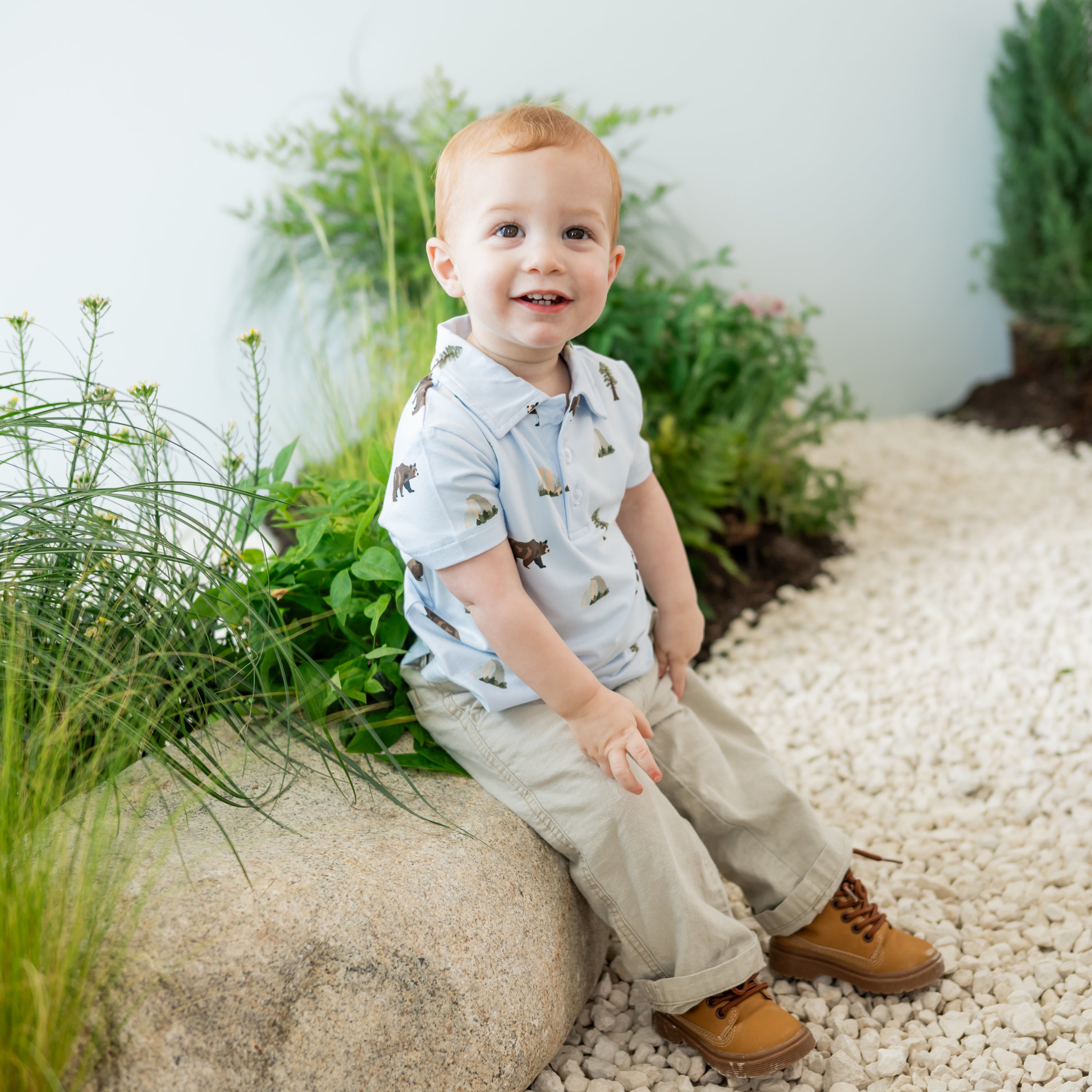 Toddler sitting on a nature trail stone wearing Toddler Short Sleeve Polo in Yosemite