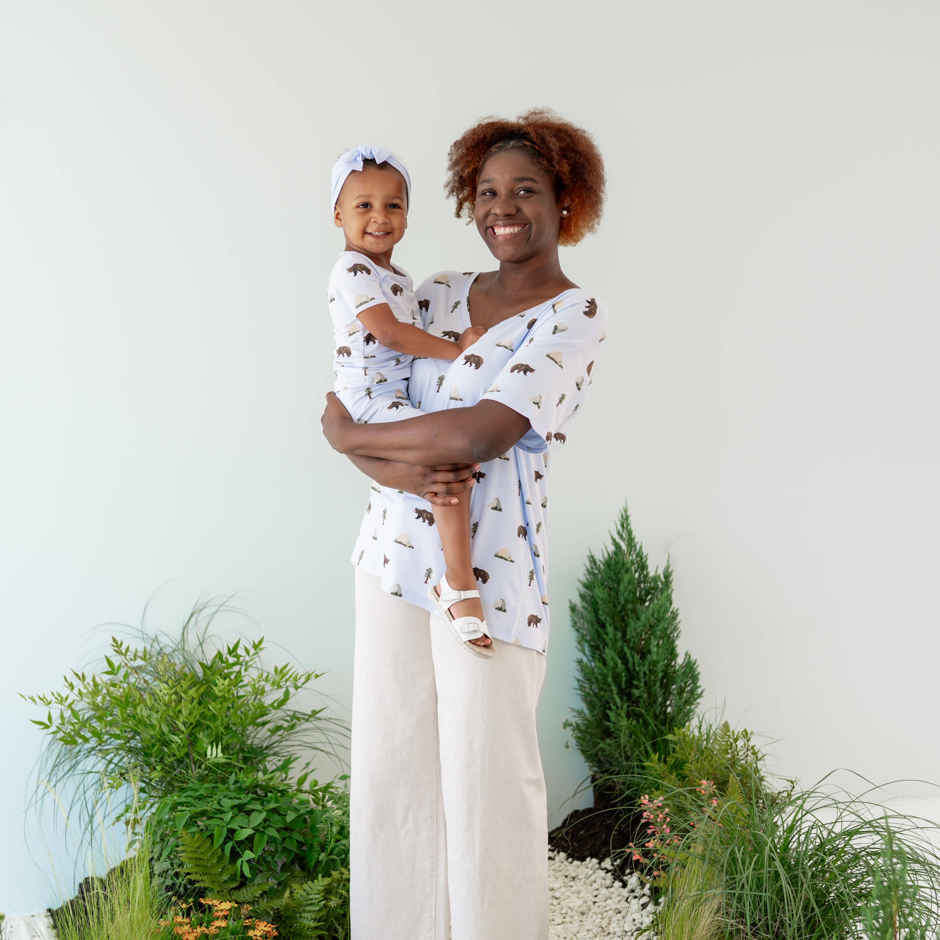 Mom in Women's Relaxed Fit V-Neck in Yosemite holding toddler in Yosemite pajamas