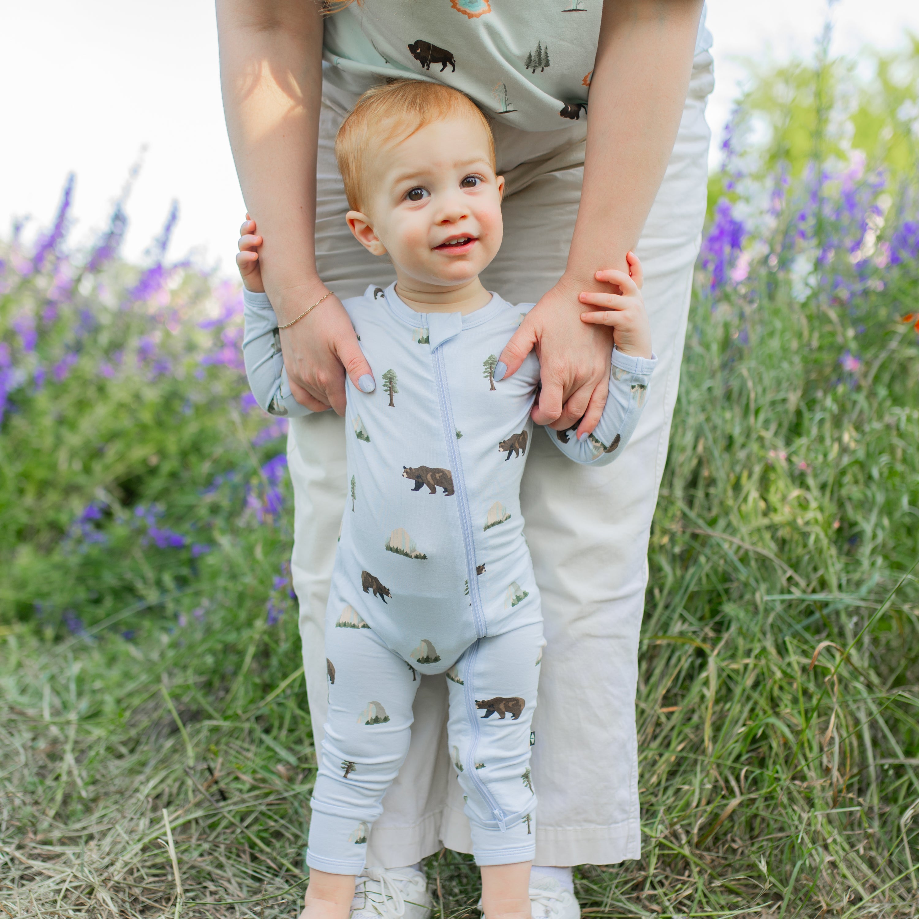Toddler modeling Zippered Romper in Yosemite in wildflower field