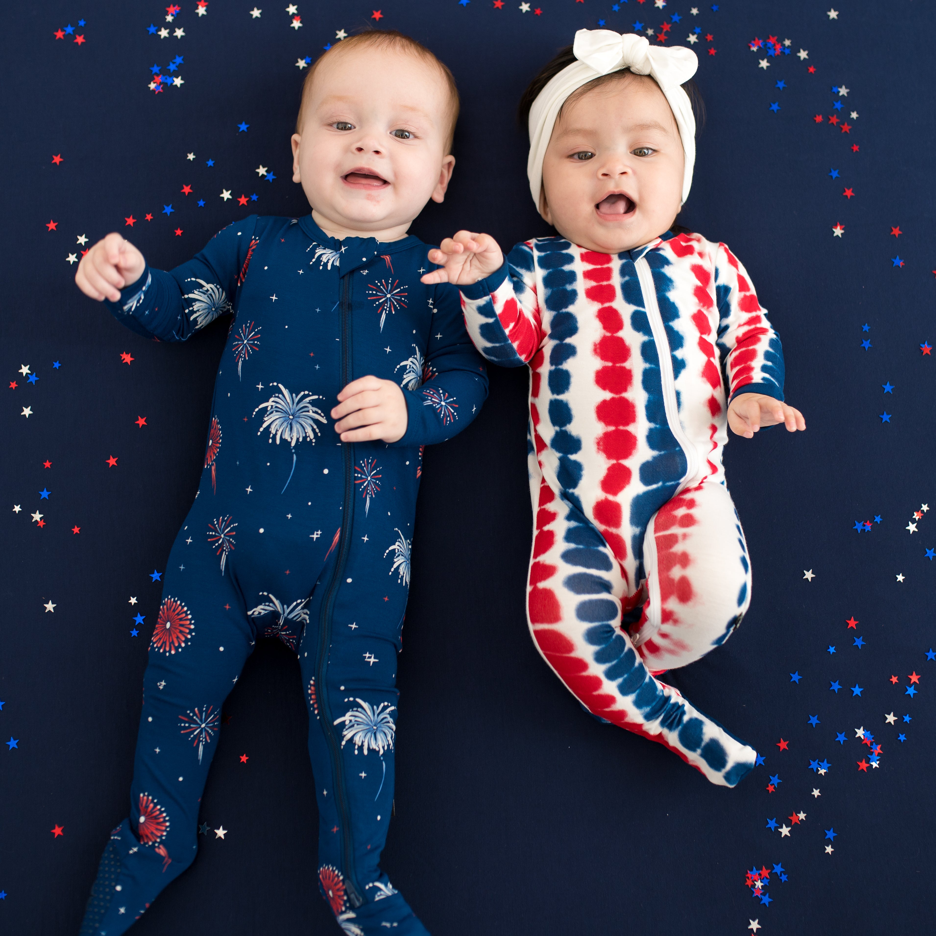 Two babies wearing Zippered Footies in Celebration and Liberty Rip Tide