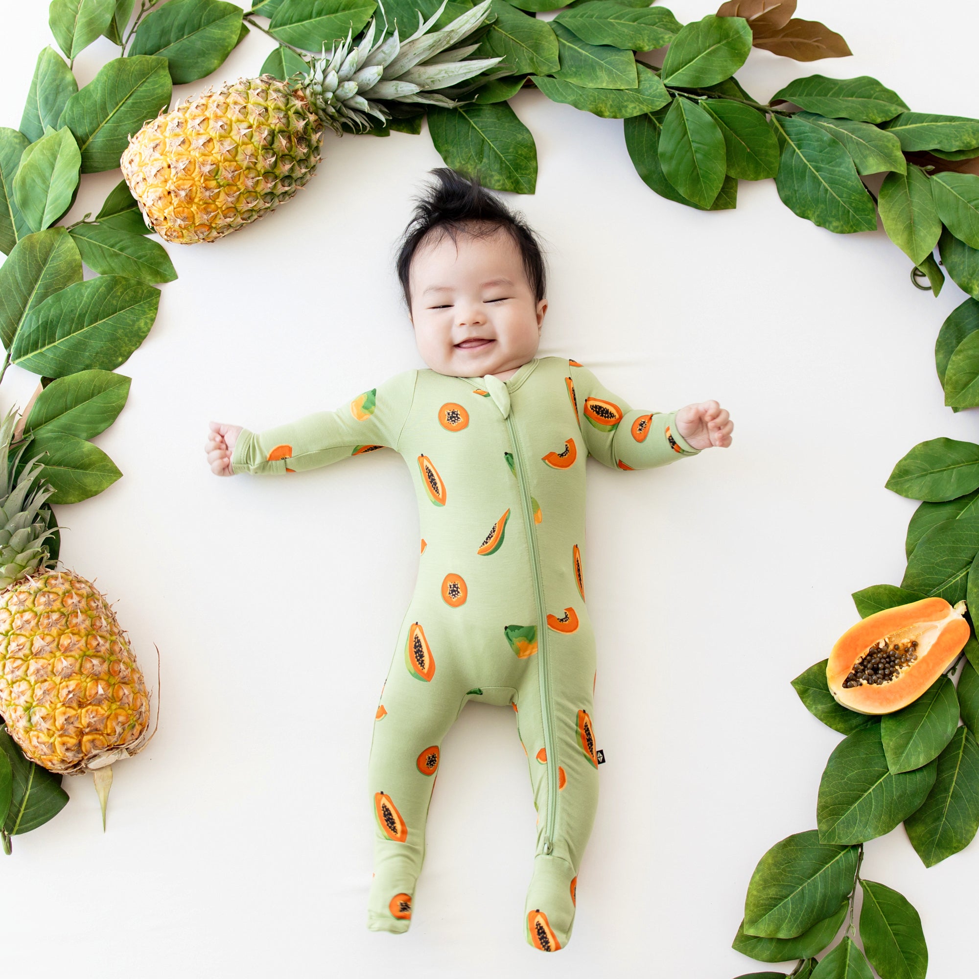 Baby smiling in Zippered Footie in Papaya