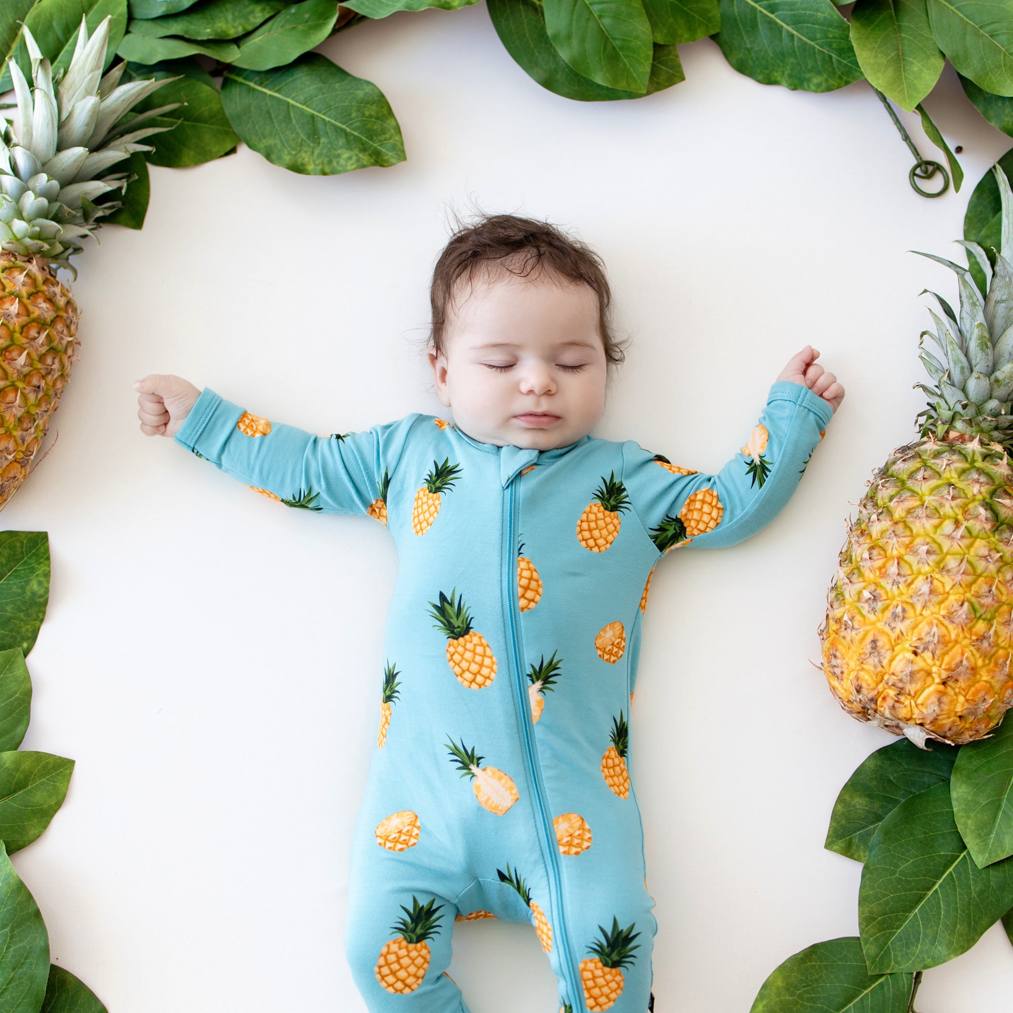 Baby sleeping in Zippered Footie in Pineapple close up
