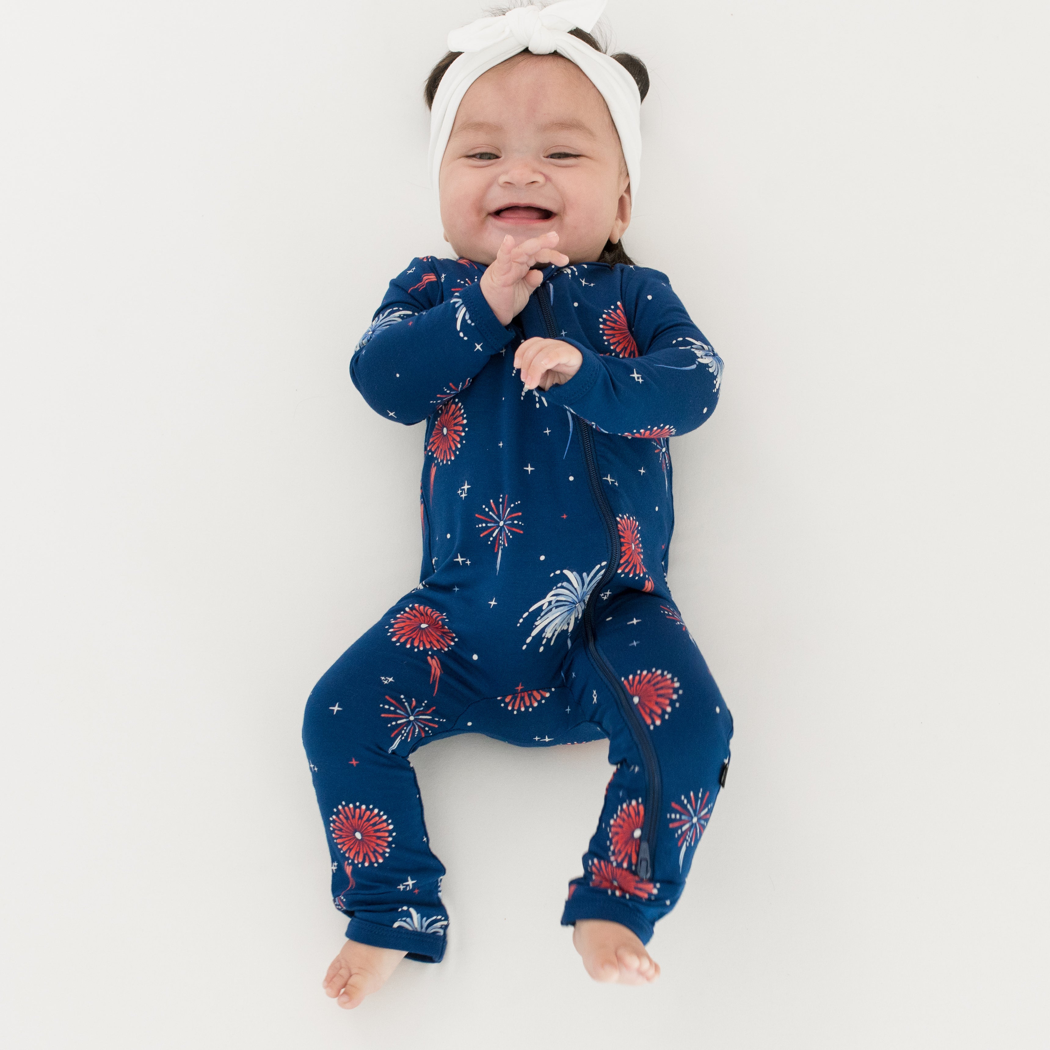 Baby wearing Zippered Romper in Celebration