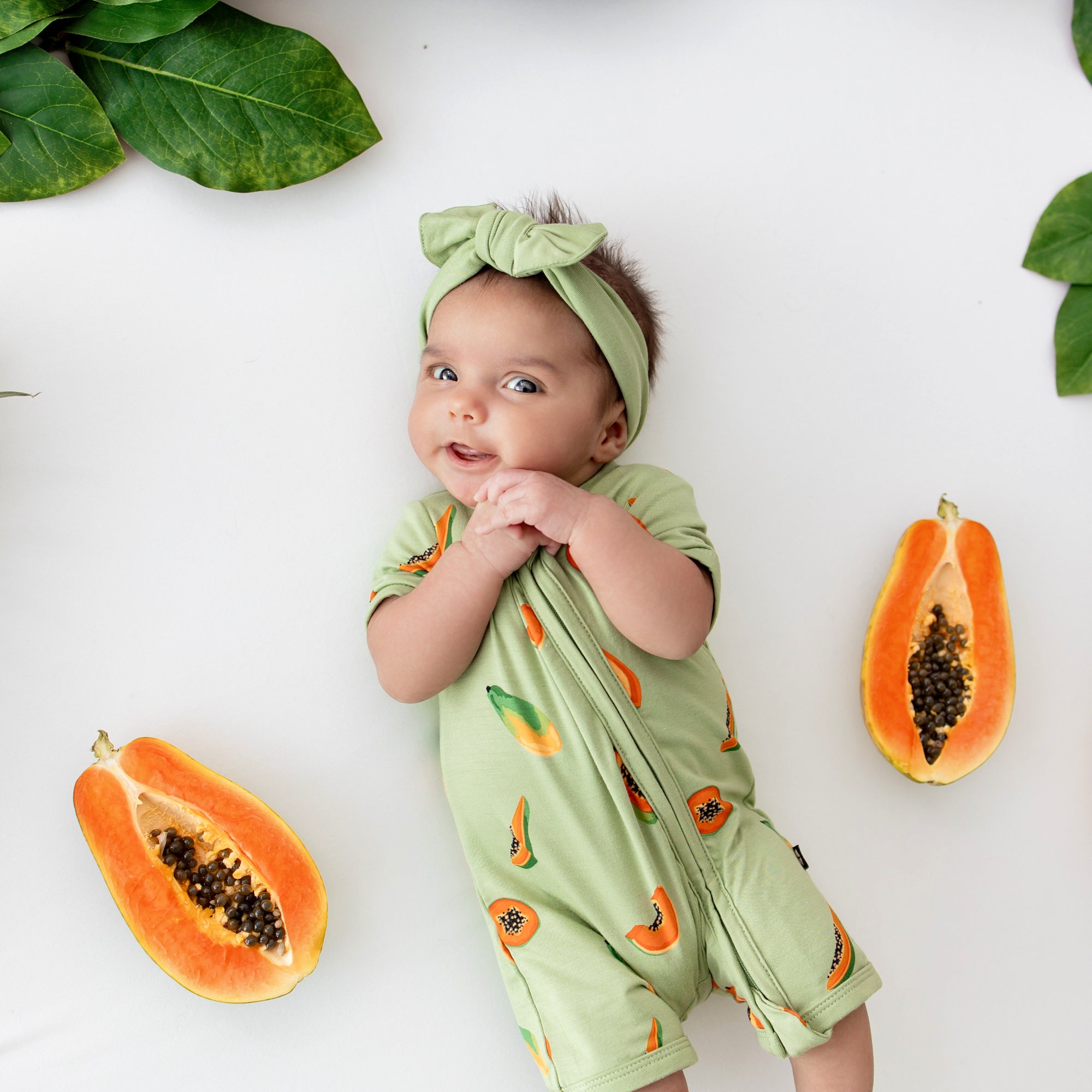 Infant wearing Kyte Baby Zippered Shortall Romper in Papaya