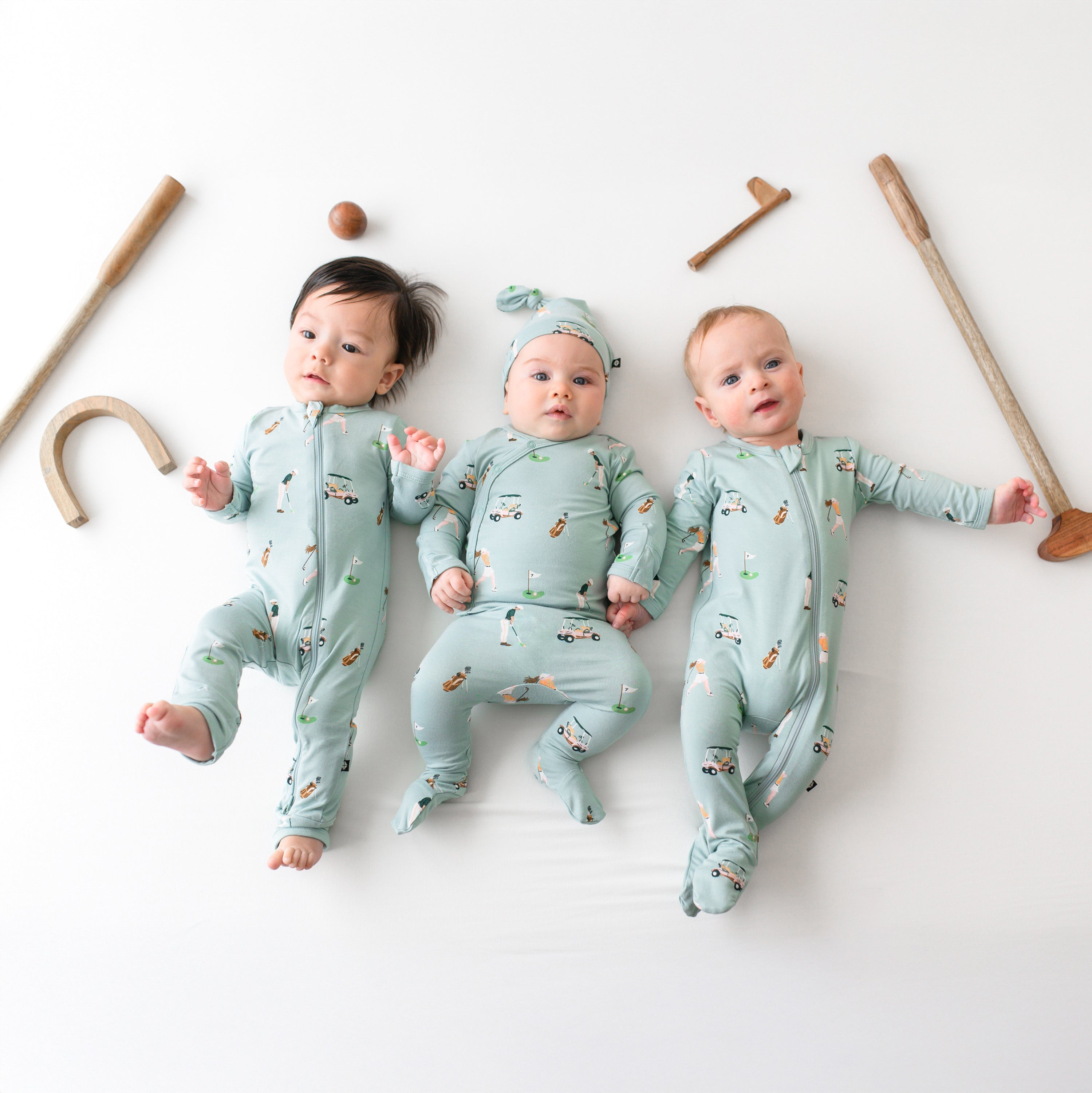 Babies wearing Kyte Baby Zippered Romper, Take Me Home Set, and Footie in Golf print